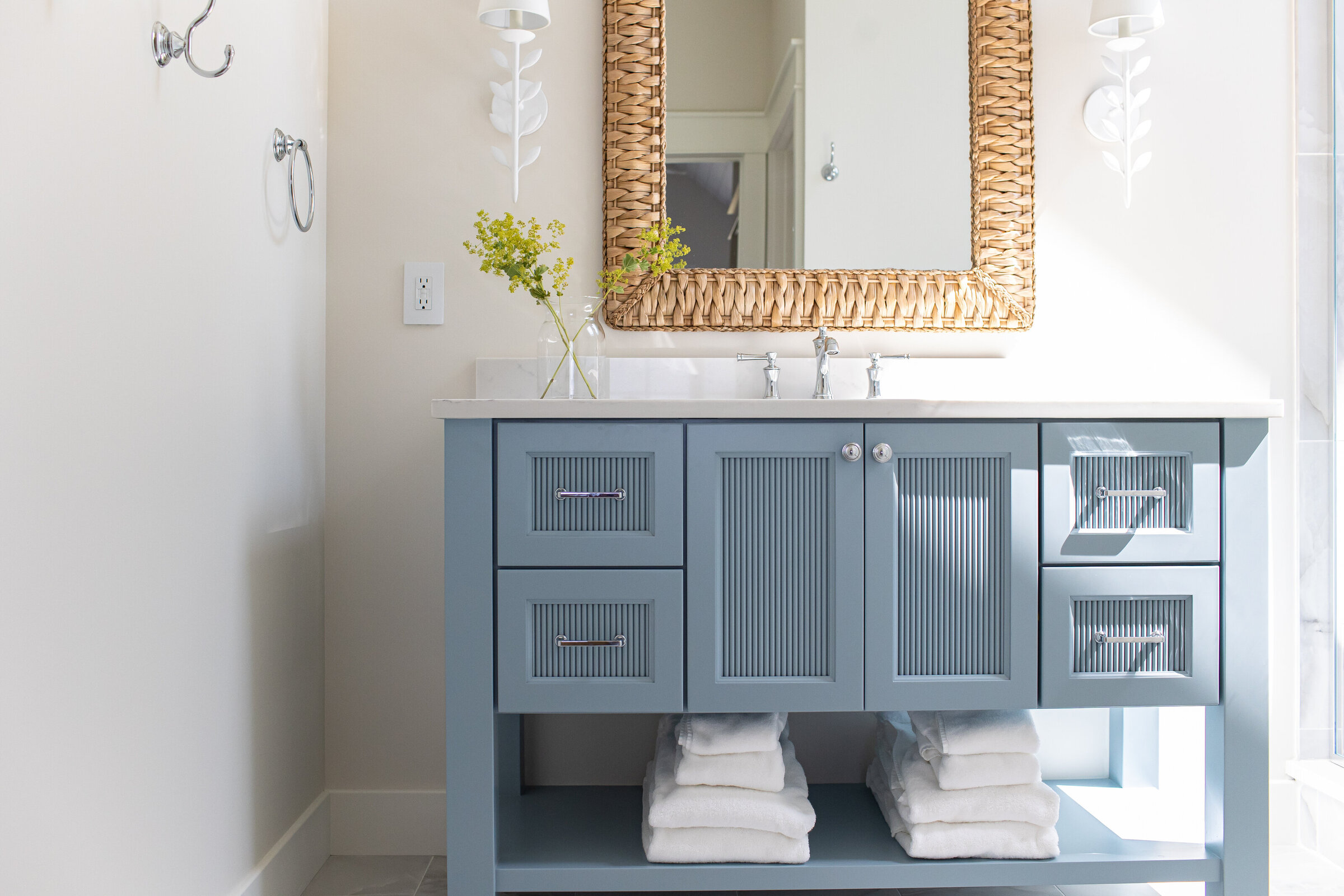 A charming bathroom vanity painted in Nantucket blue, adding a touch of coastal elegance to the space. The bold color choice enhances the overall aesthetic, creating a striking focal point in the bathroom.