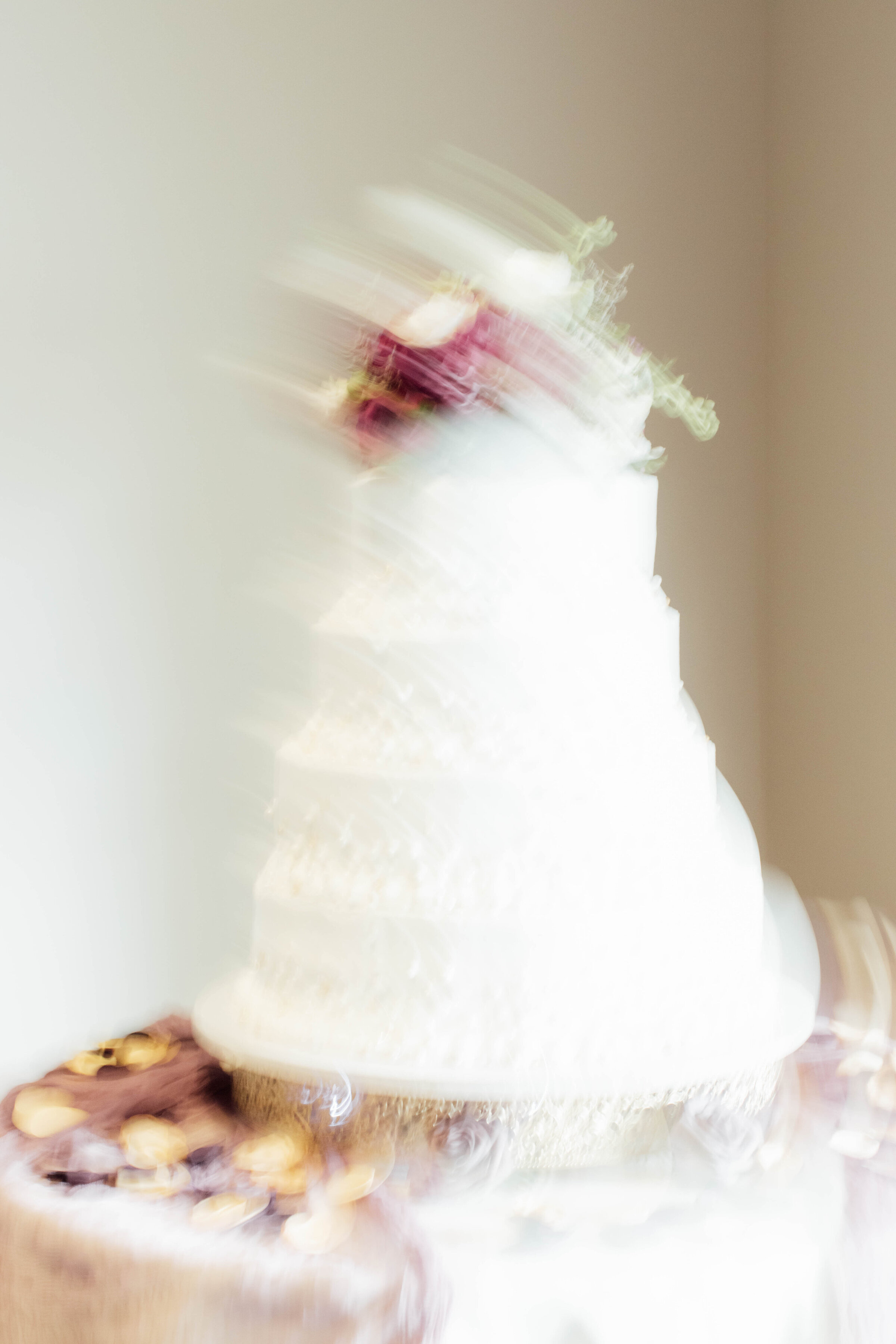 Soft-focus image of a tiered wedding cake at the reception.