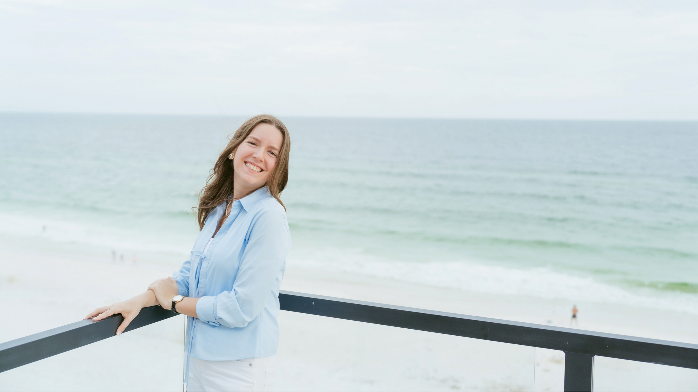 smiling portrait of Matilyn on the balcony overlooking the beach