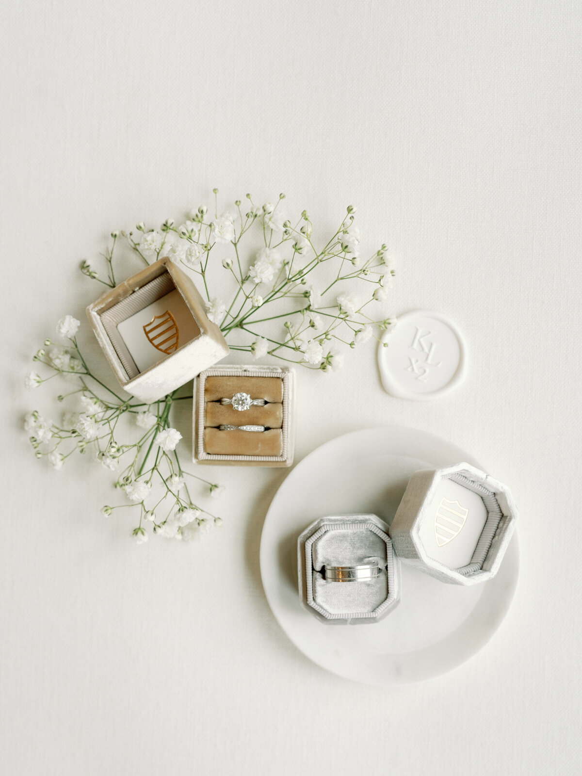 flat lay of wedding rings on white backdrop with baby's breath