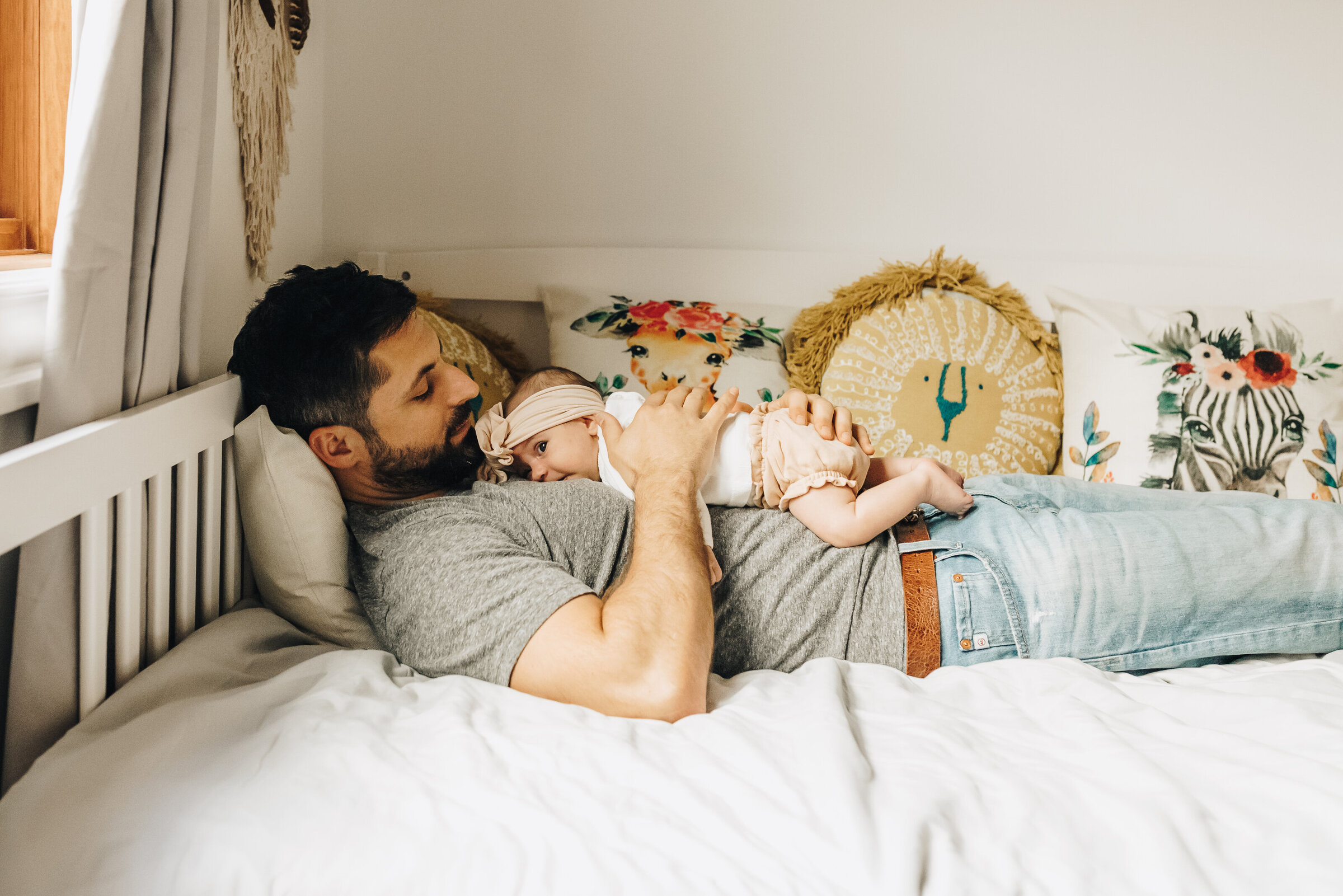 Dad Snuggles Baby Lying on Bed