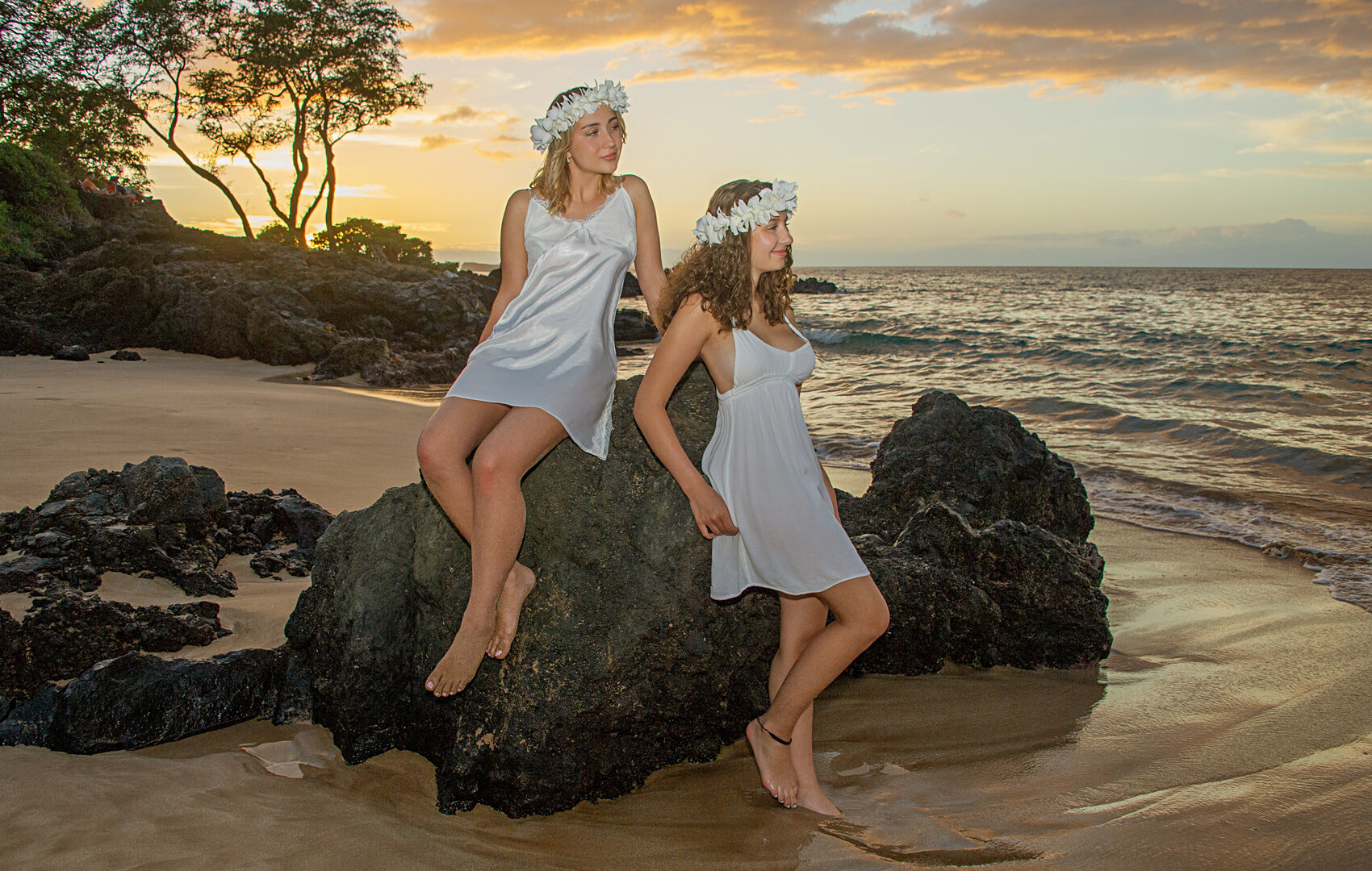 Sisters on the beach at sunset with beautiful flowers on their head