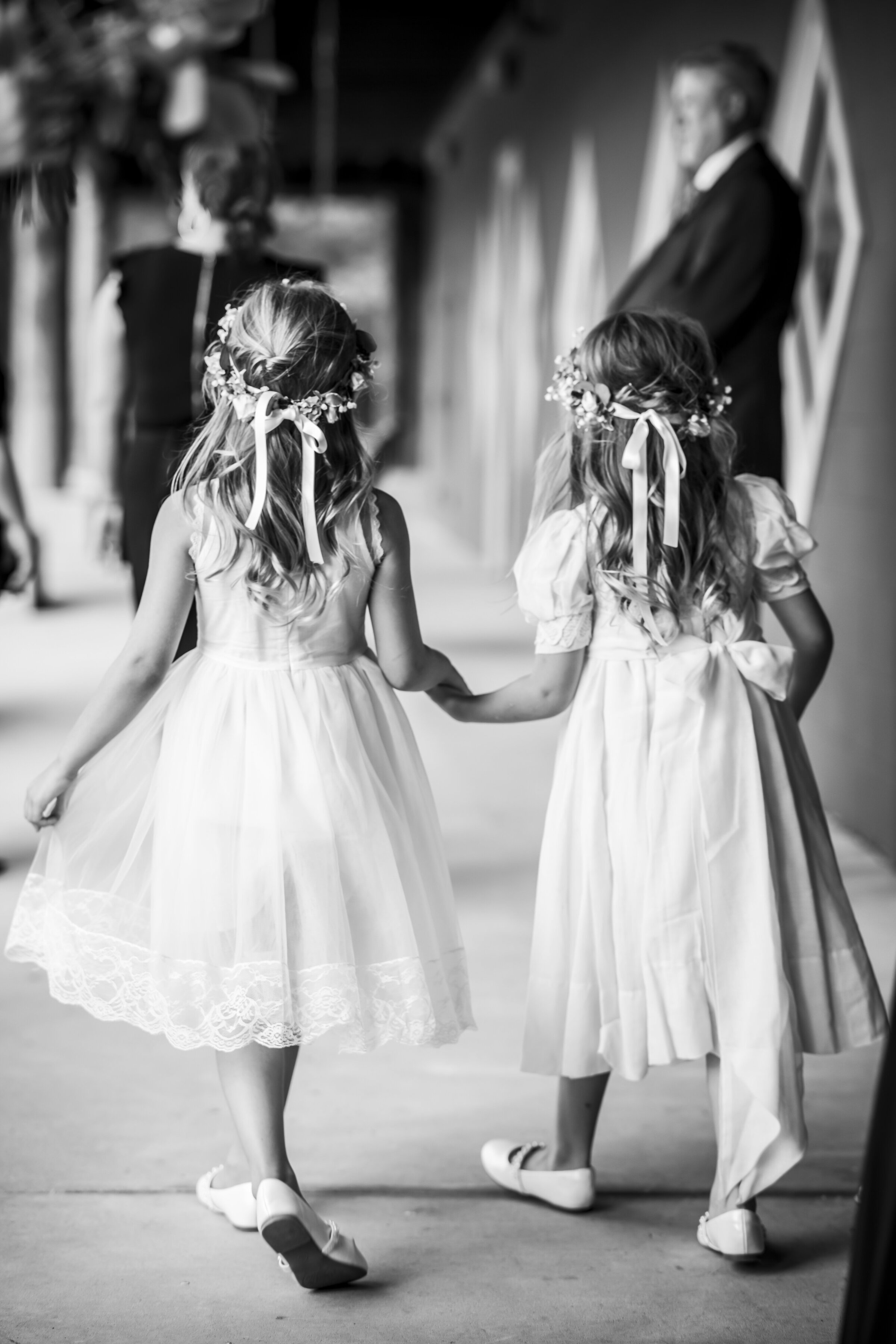Two flower girls holding hands.