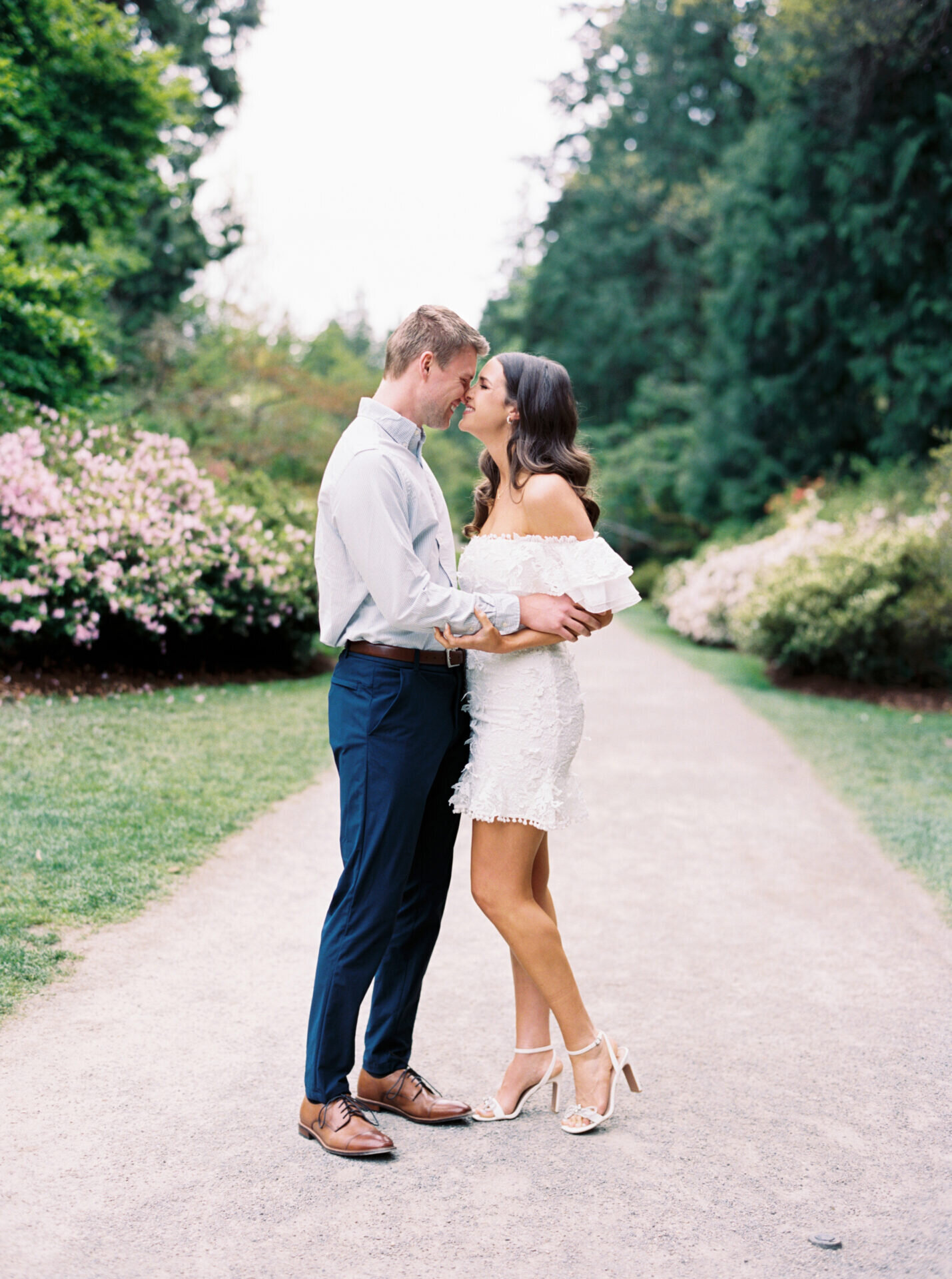 couple touching noses during engagement session at park in the spring time