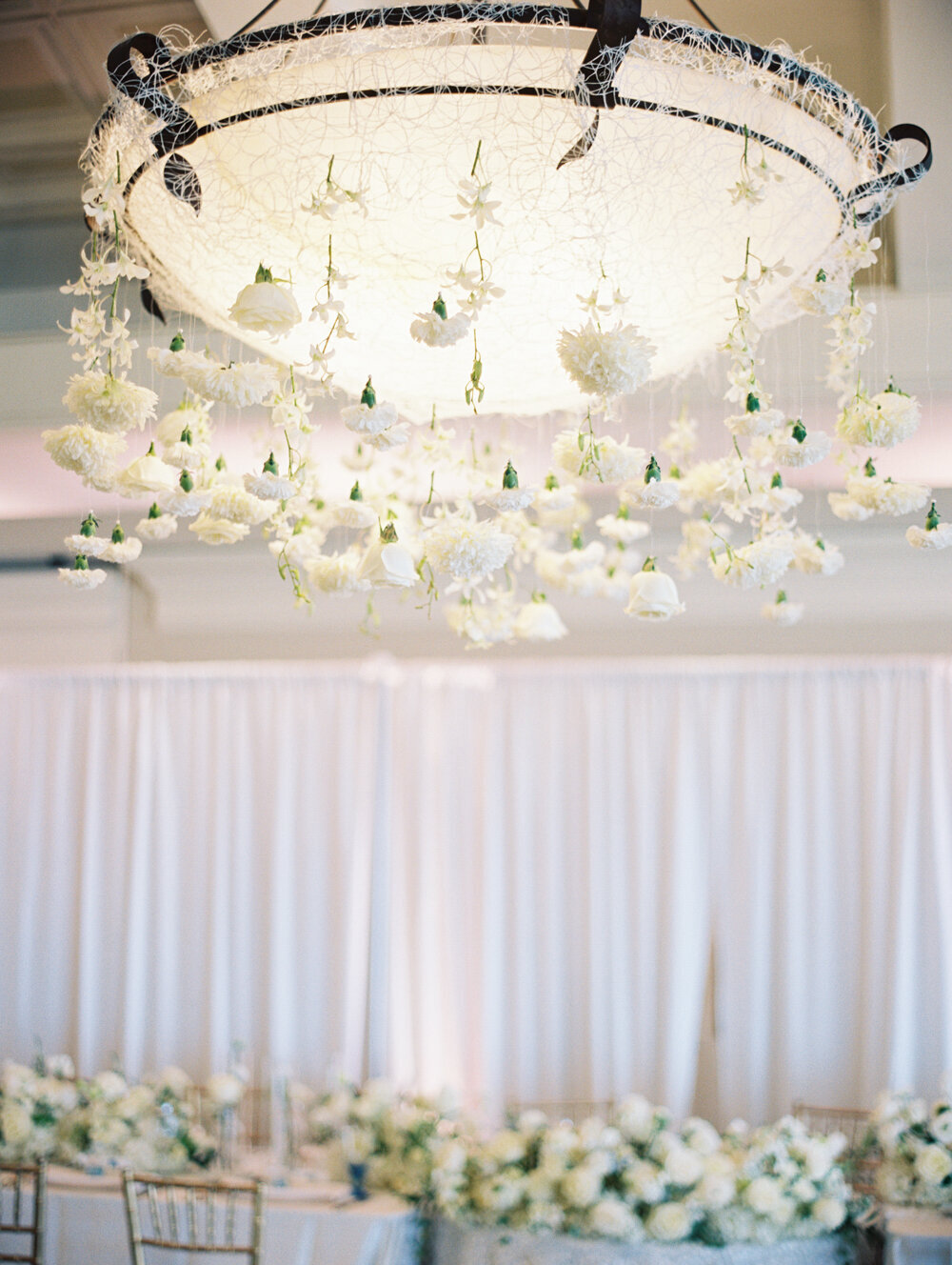 white roses hanging from wedding chandelier