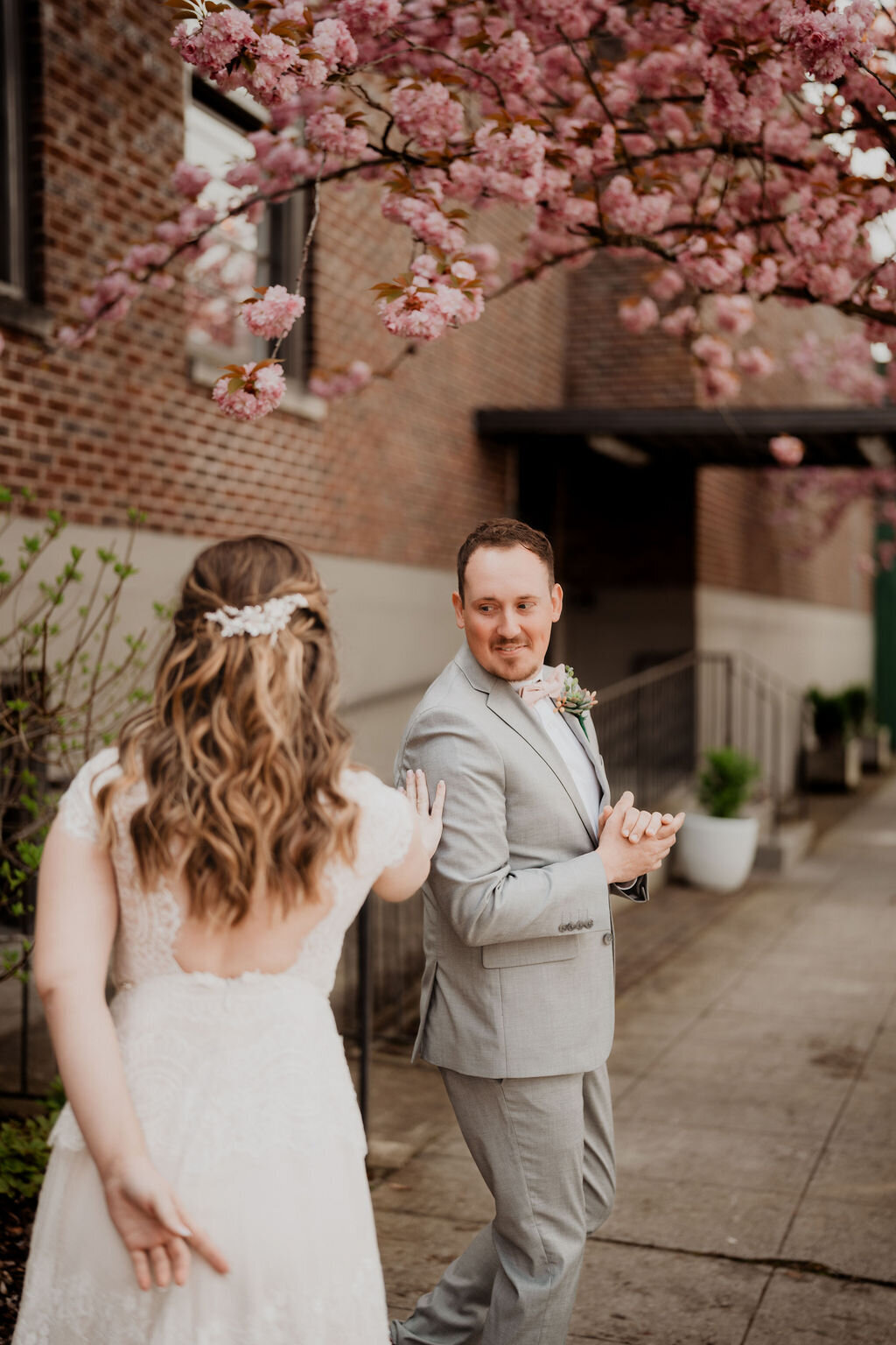 couple photos first look during wedding under the cherry blossoms