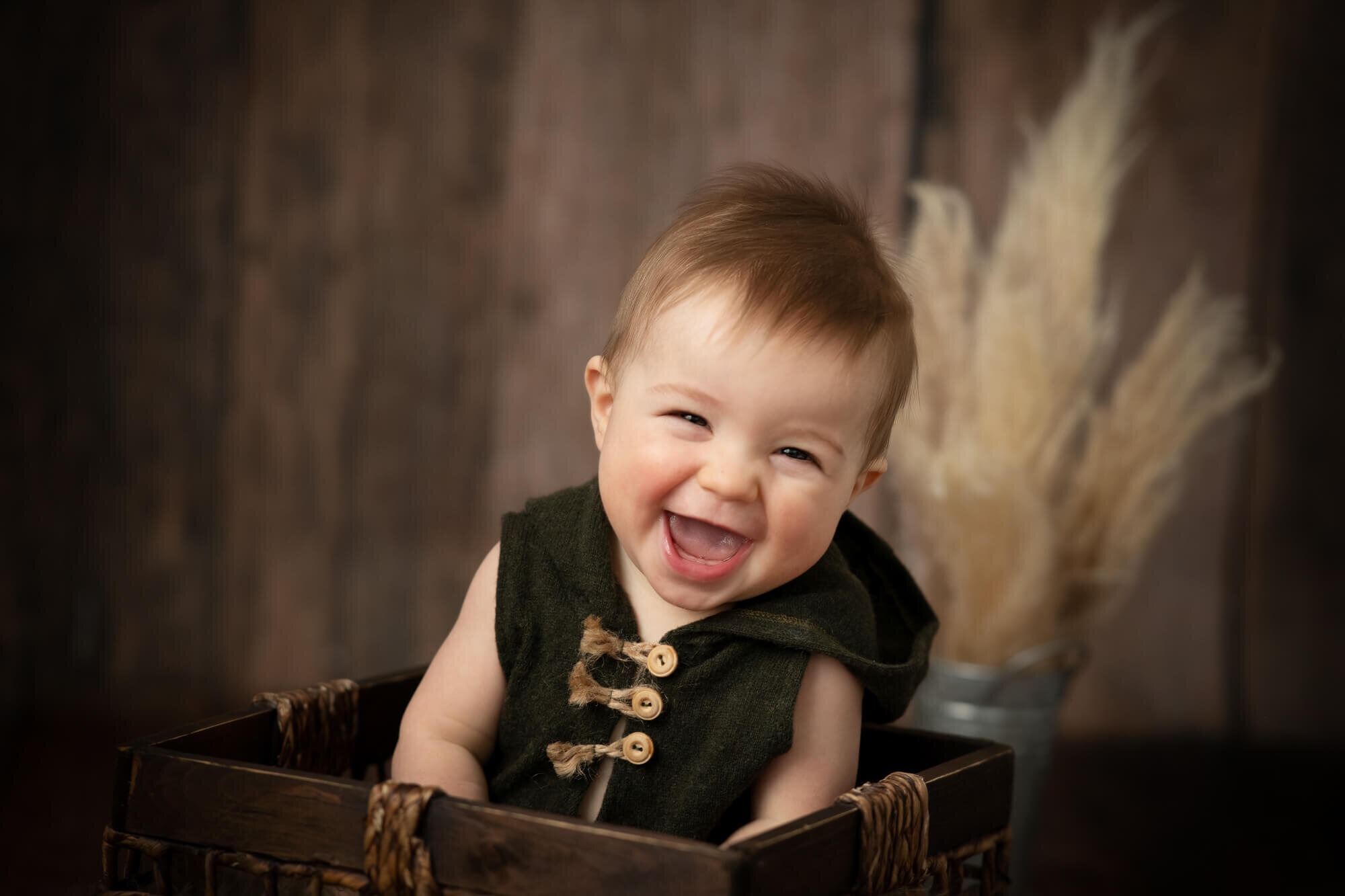 Baby boy with olive romper and pampas grass
