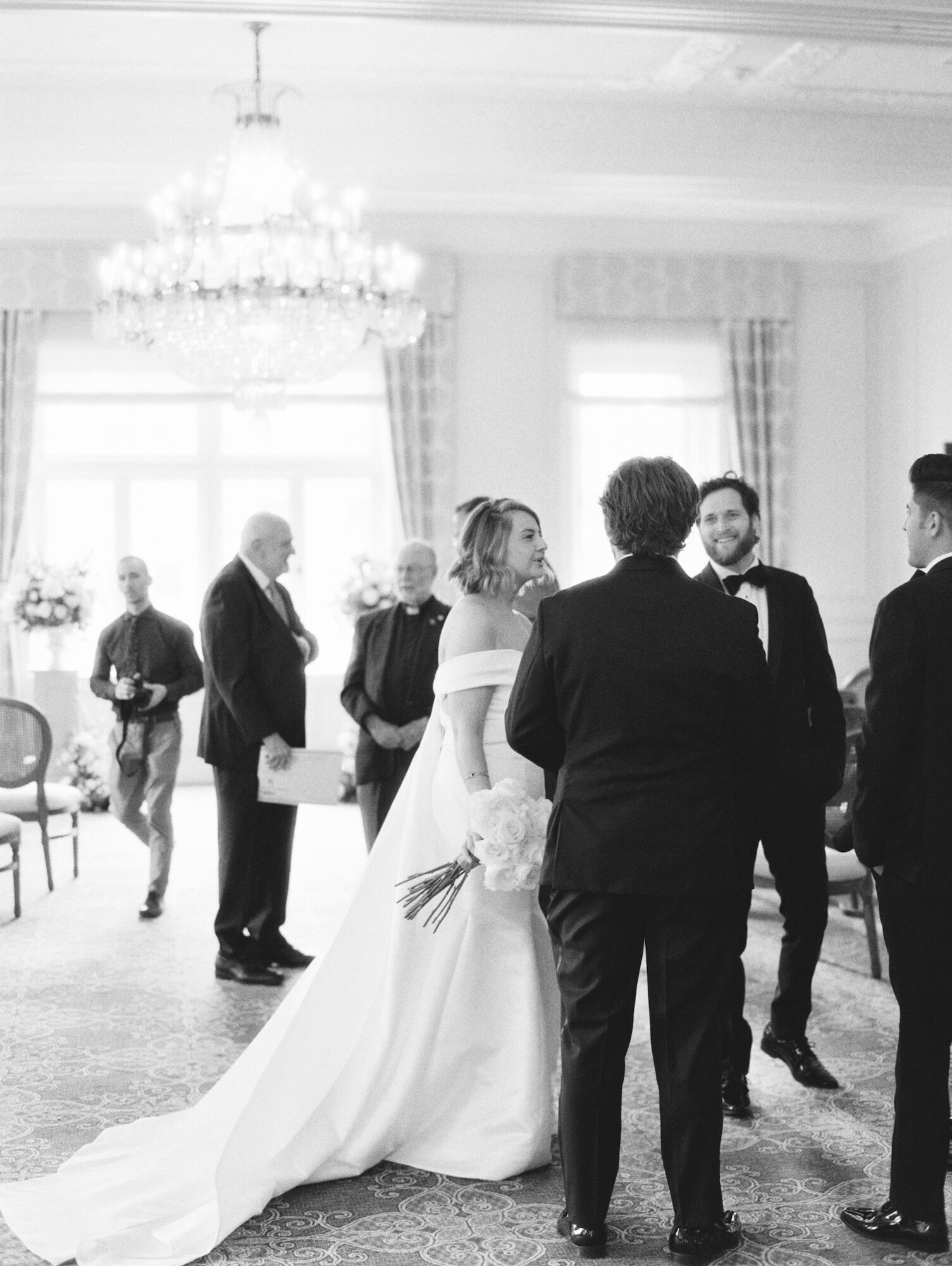 black and white photo of bride mingling with guests inside historic seattle wedding venue