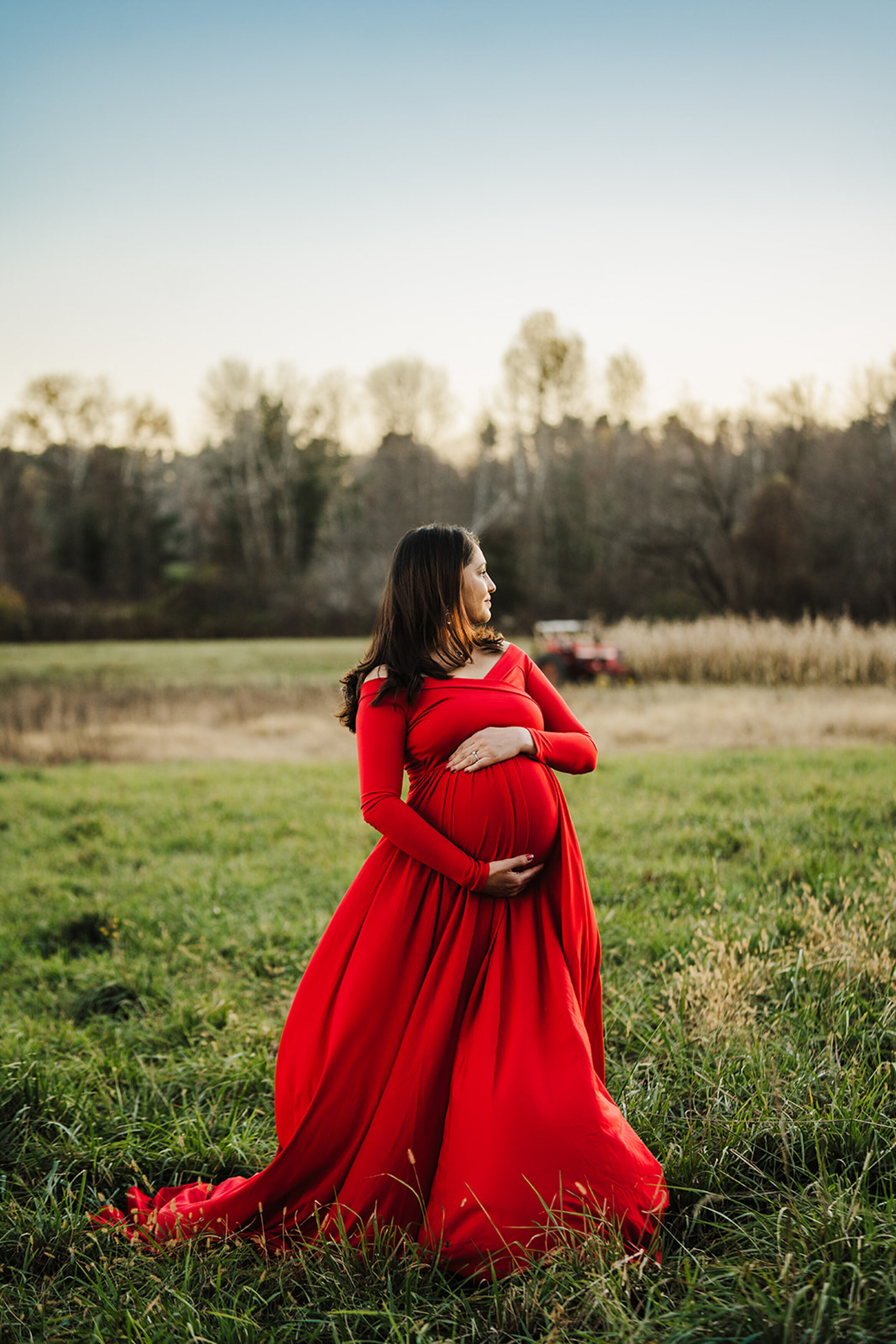 pregnant woman in red dress in green field