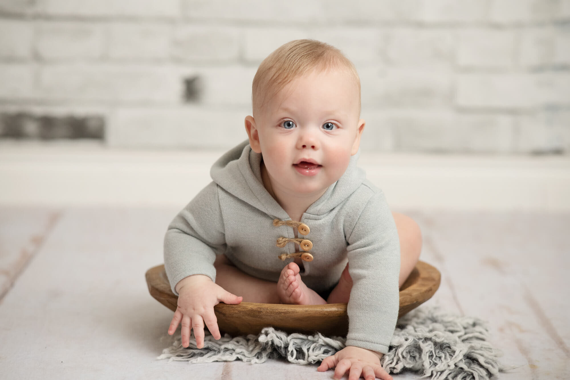 Sitter with grey outfit and white brick wall
