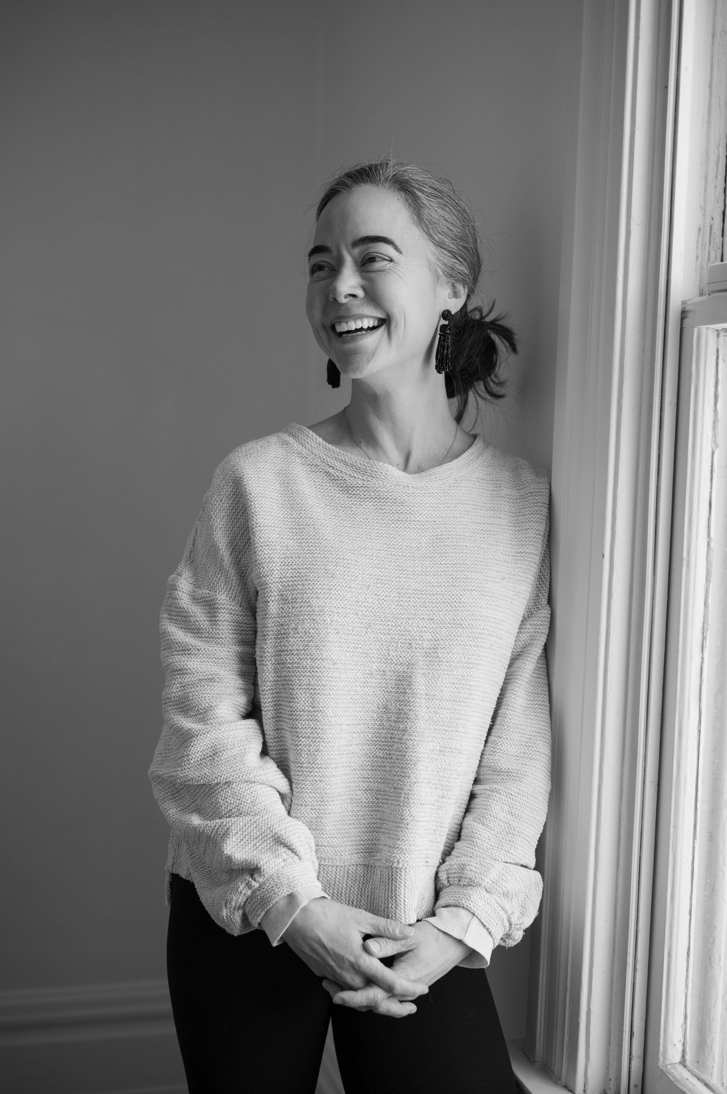 Dr. Tanner Wallace, founder of CPTSD Medicine, standing near a window and smiling, representing warmth, safety, and trust in trauma healing.