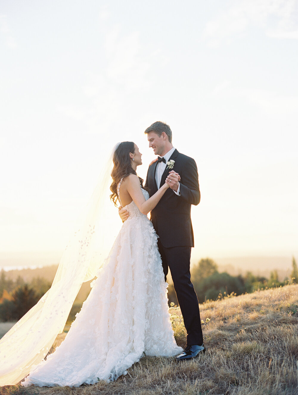 bride and groom dancing outside at golden hour on film