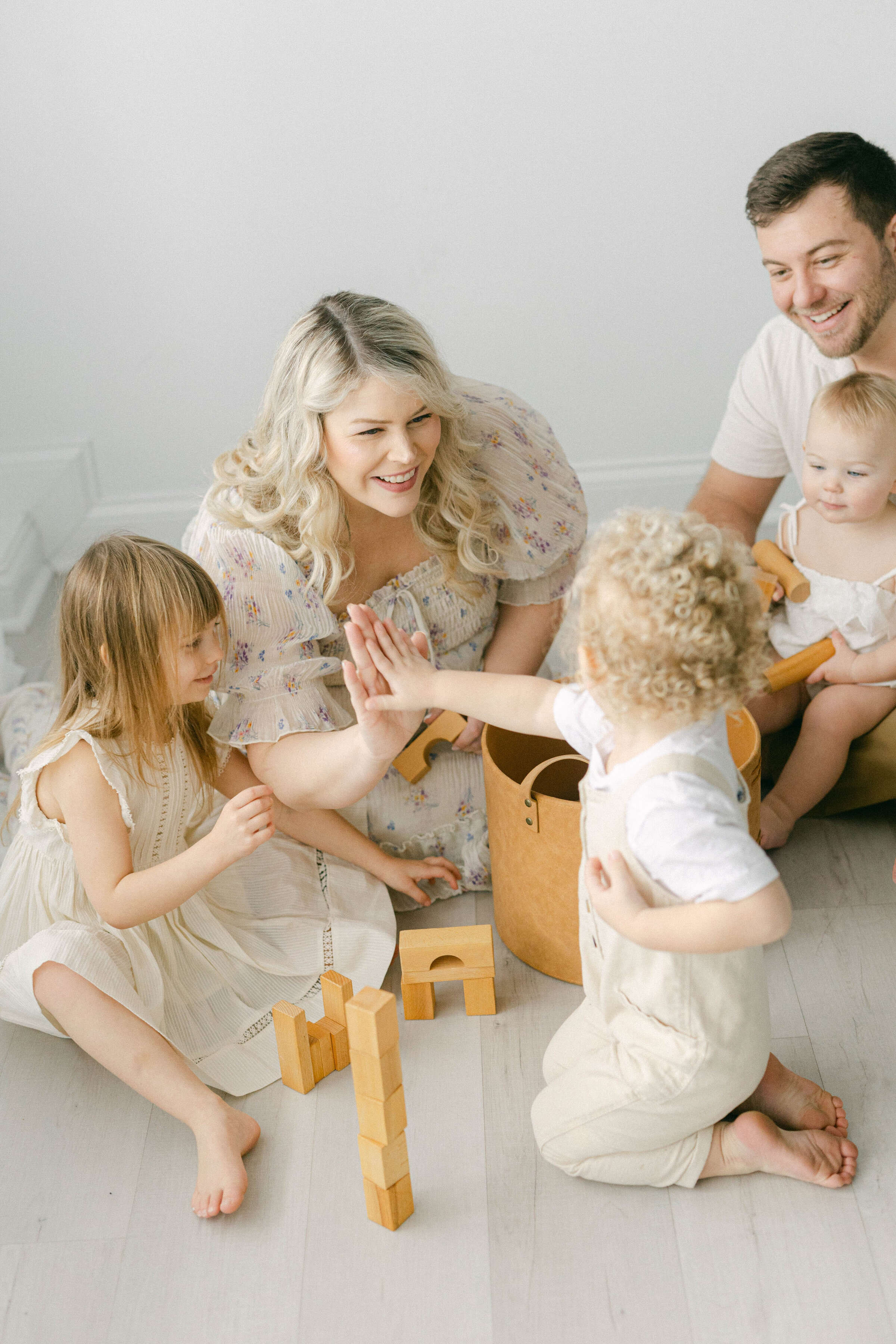 women giving little boy high five while playing blocks  knoxville tennessee newborn photographer