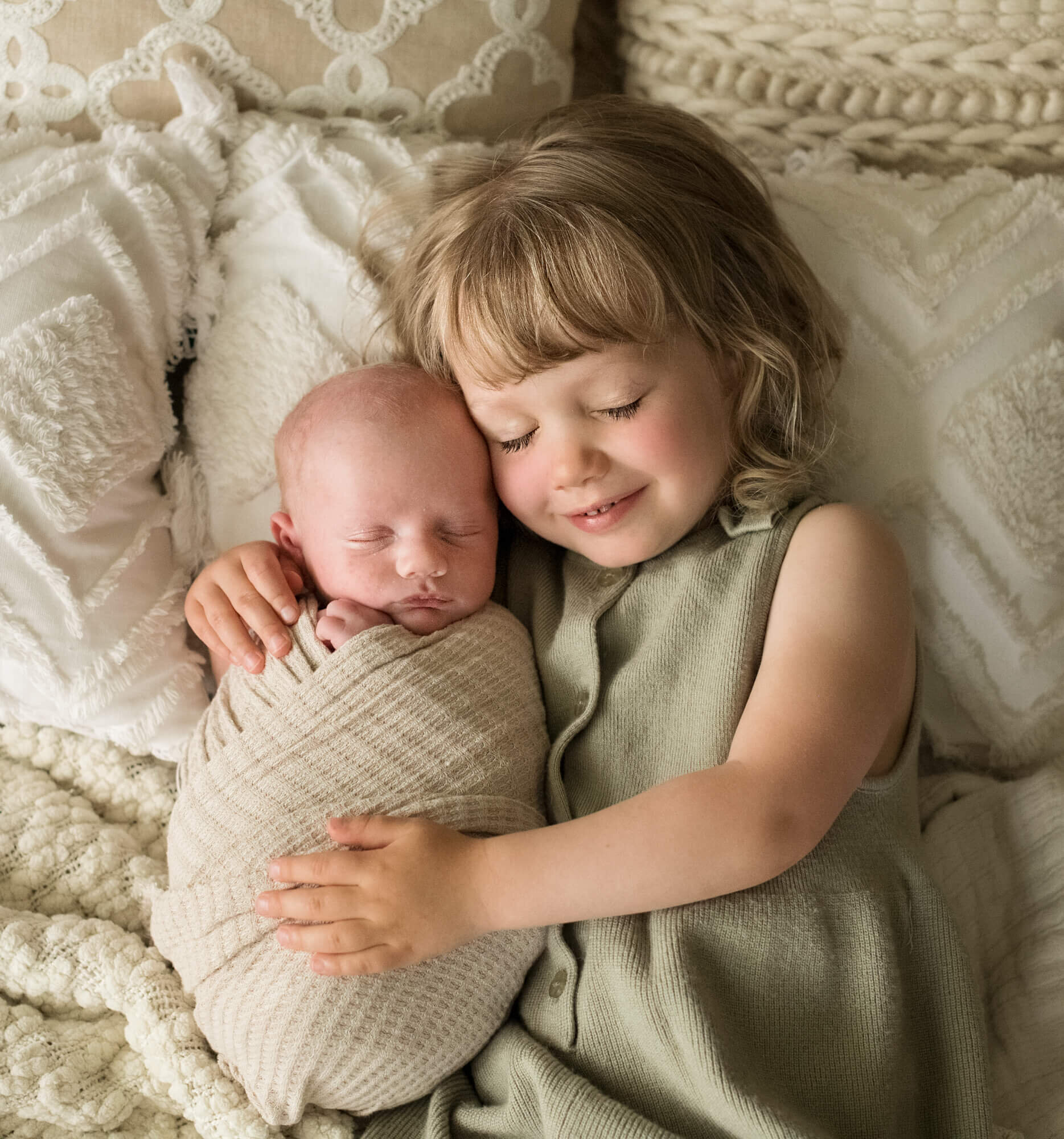 older sibling holding newborn baby brother