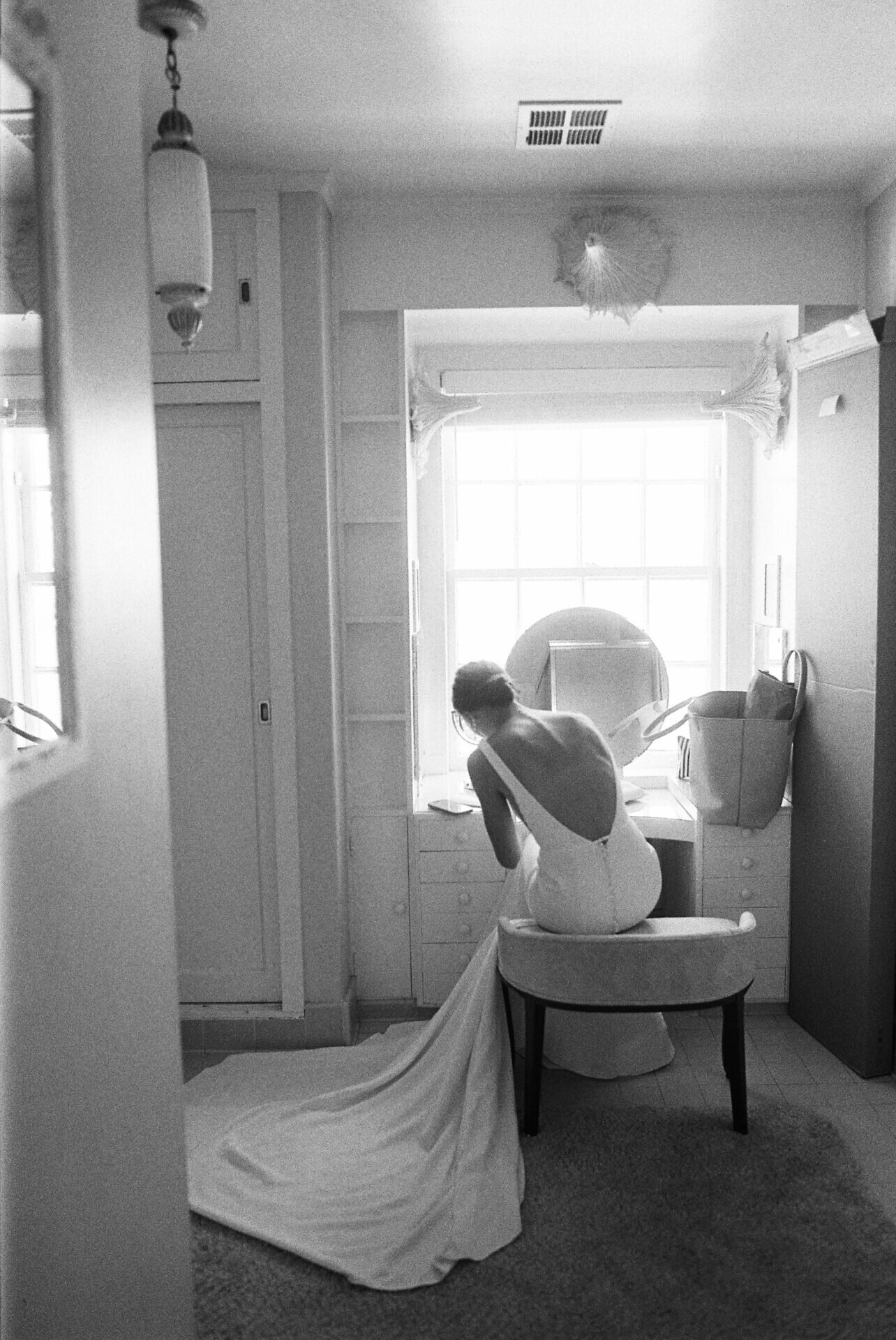 black and white photo of bride writing her vows in the admiral's house bridal suite