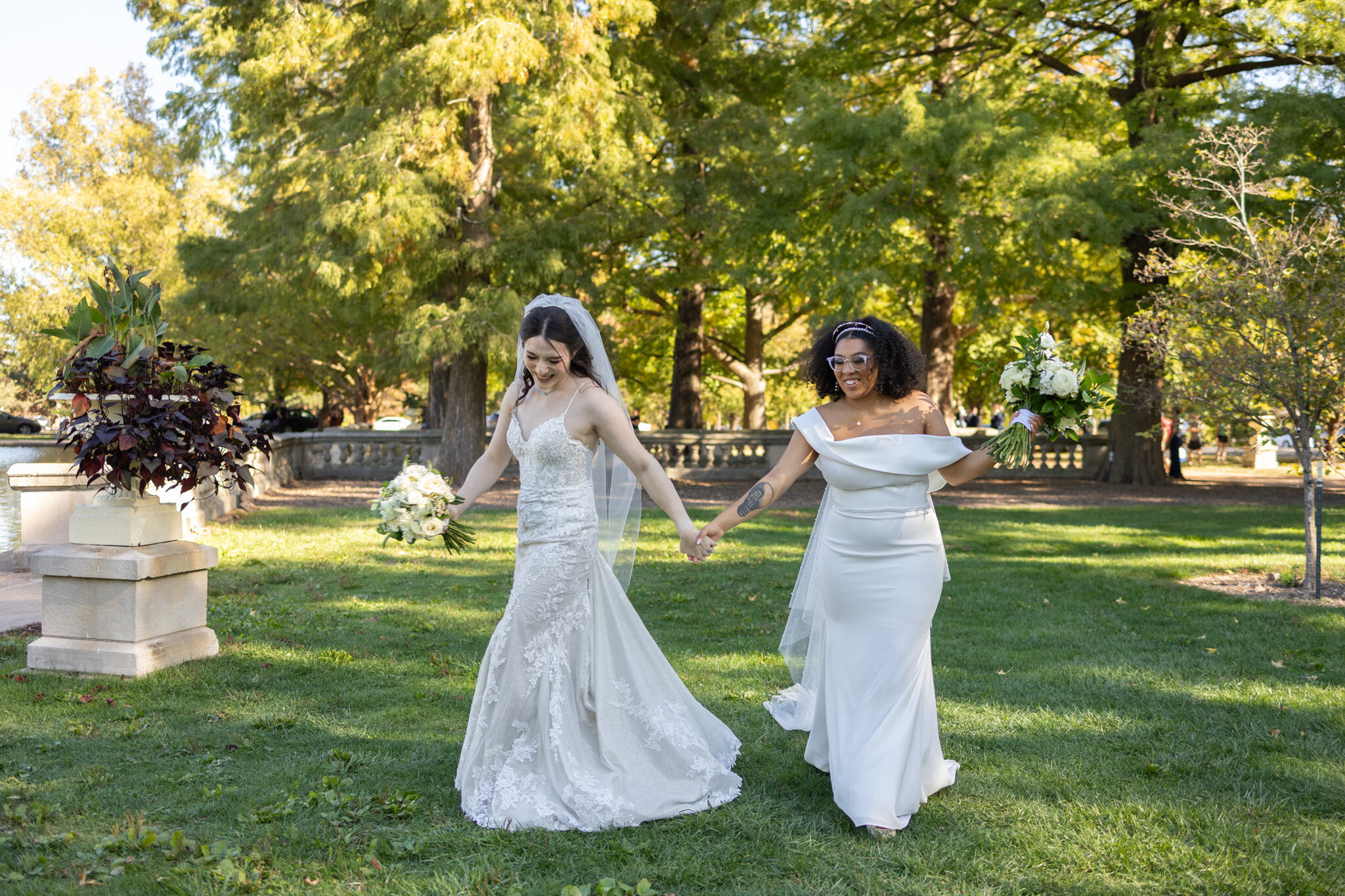 Two brides holding hands at Tower Grove Park