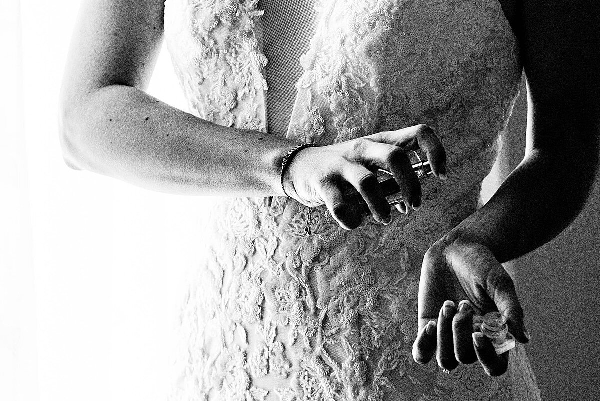 Black and White close up detail photo of bride putting perfume on her wrists