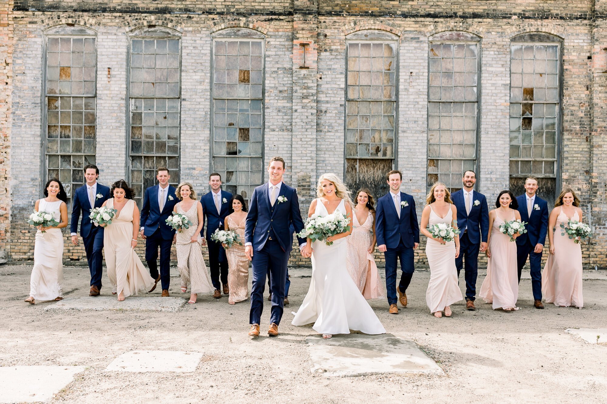 Bridal party walking together with bride and groom in the middle, taken by wedding photographers in minneapolis