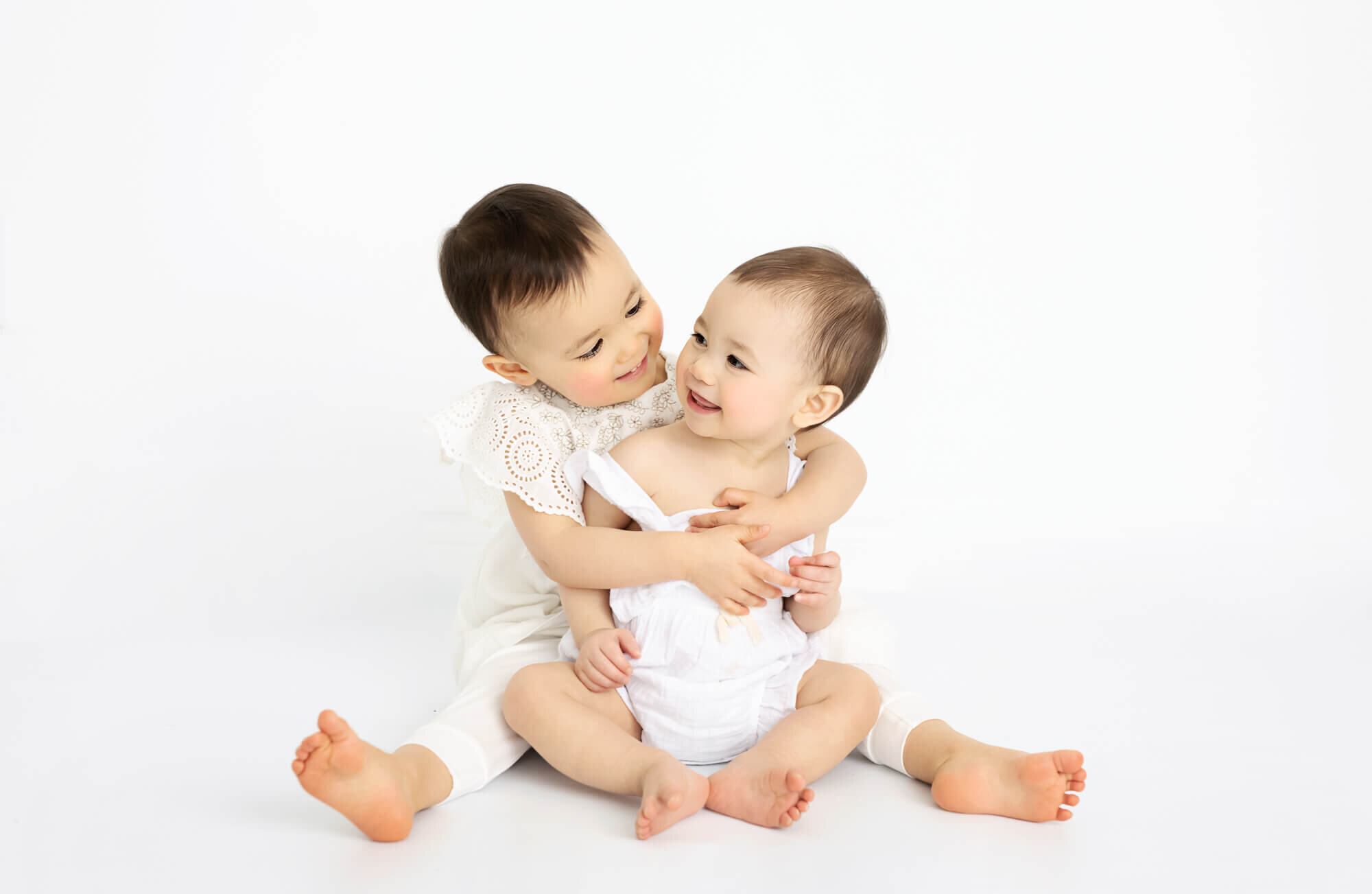 Siblings in white background and white clothing