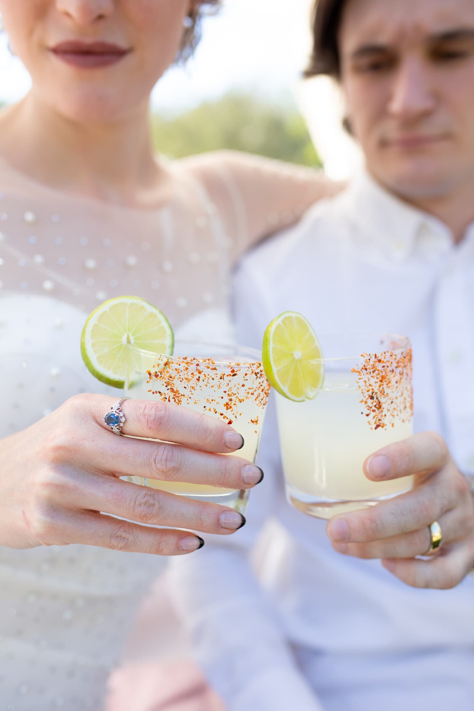 bride and groom clinking  glasses with signature cocktails . merrimon-wynne wedding photographer.