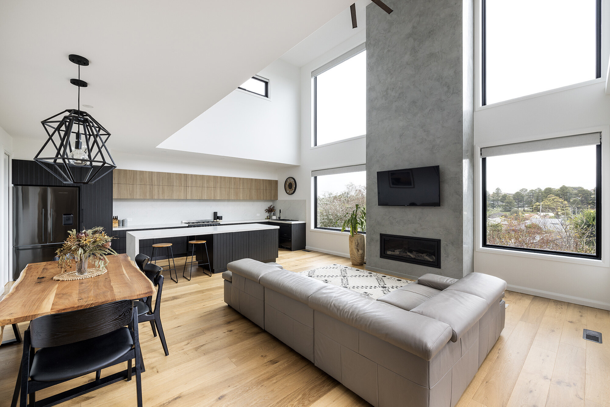 Concrete oillar double height ceiling leather couch in modern home