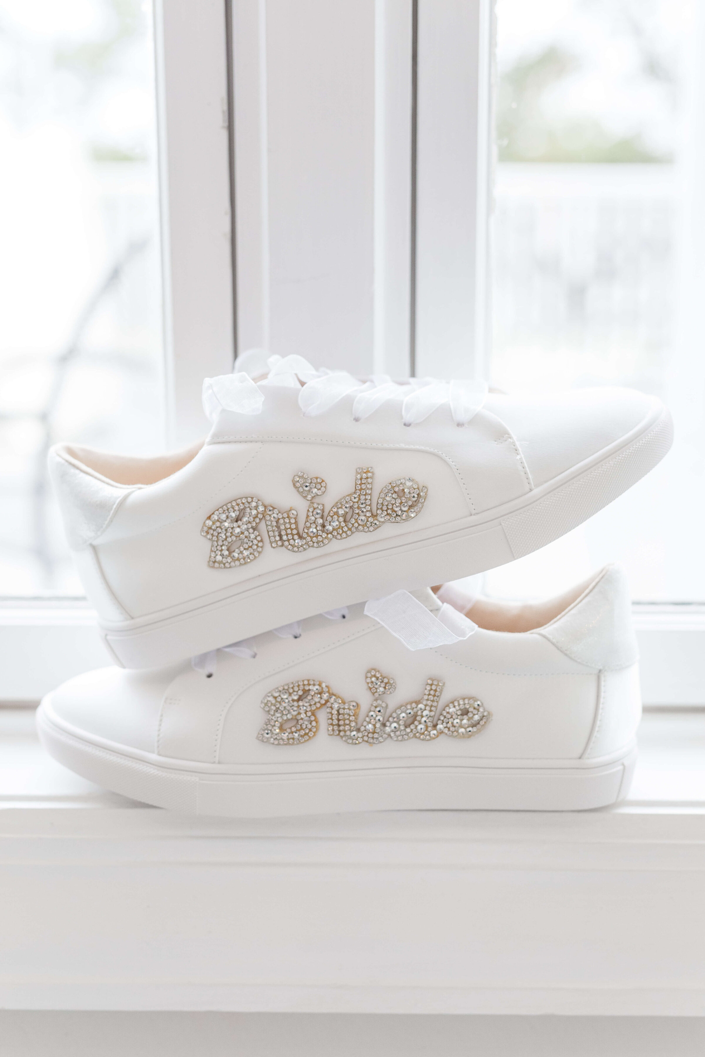 A pair of sneakers in a window that say Bride on the side.