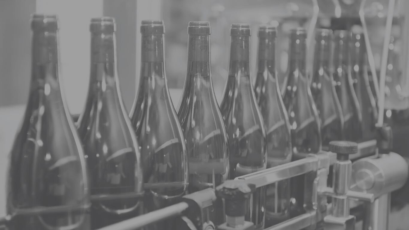 On-site wine bottling setup with labeling and capping in progress