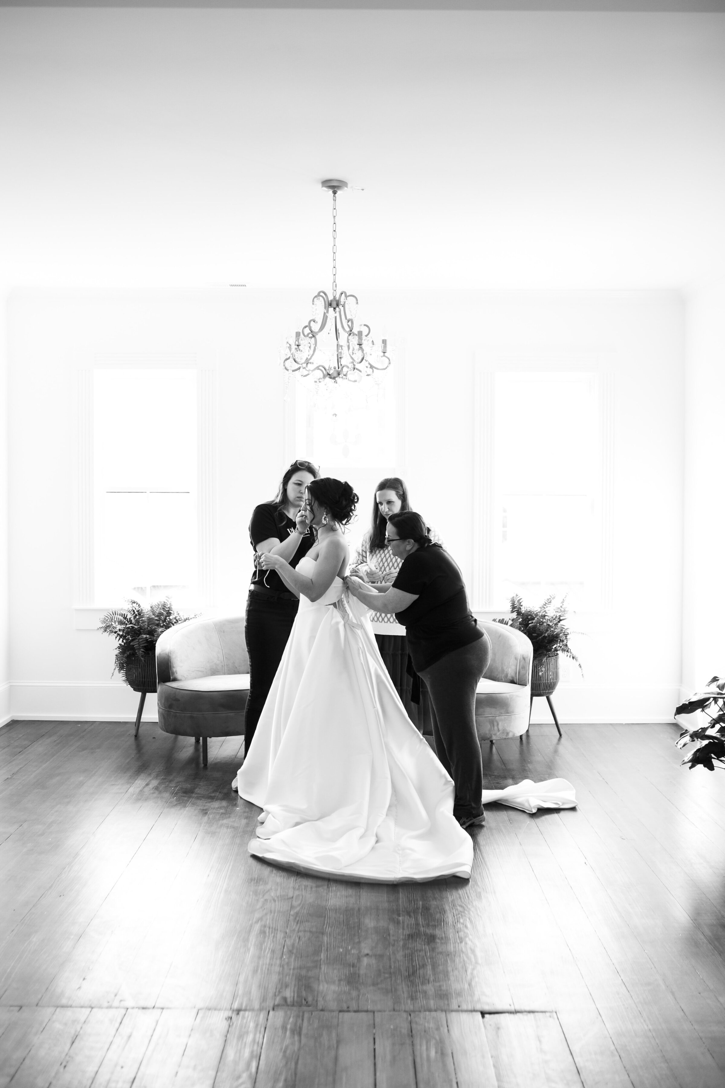 Bride putting on her wedding dress at the spacious bridal suite at the Landon Estate.