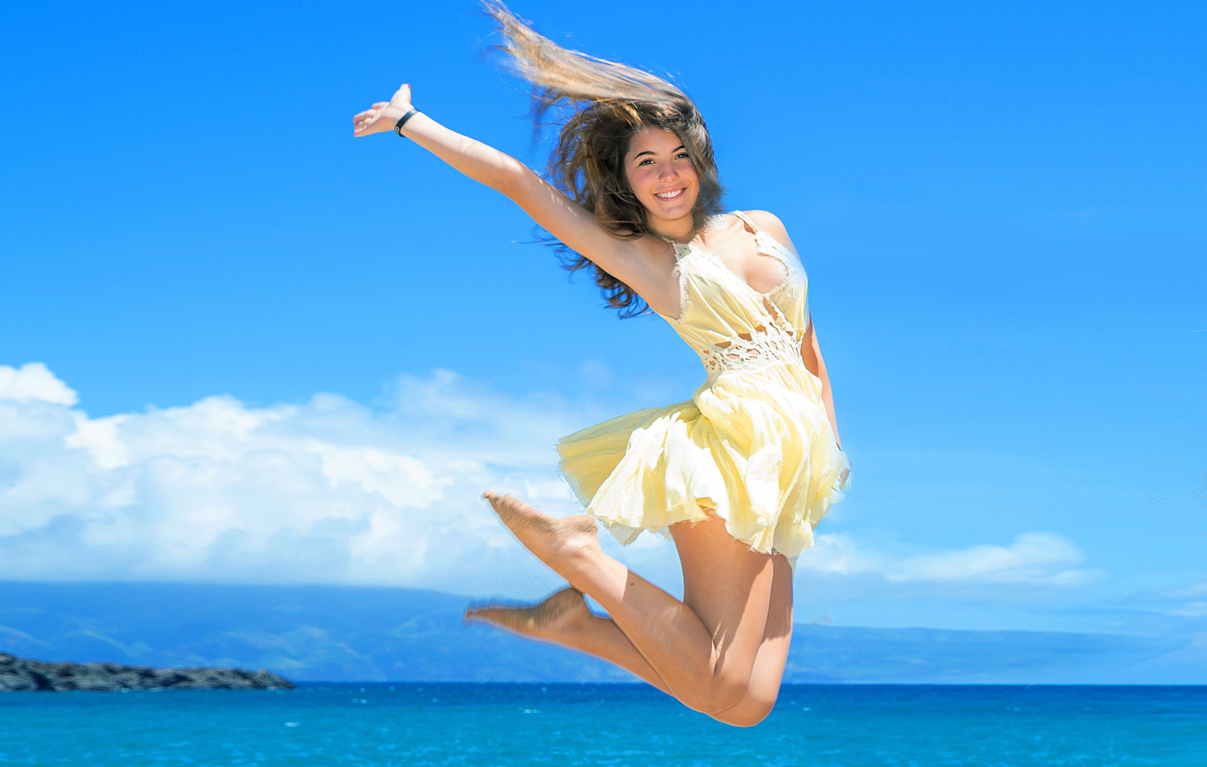 jumping high in the air on a Oahu beach.