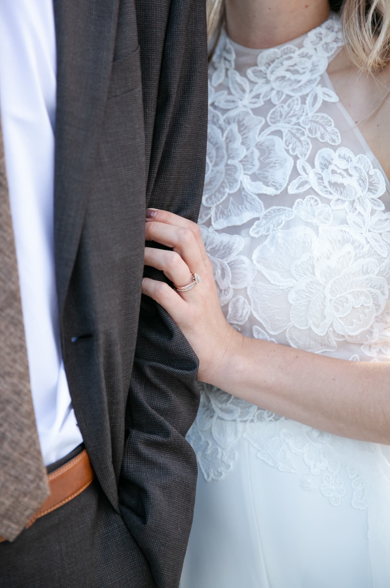 closeup of bride's hand holding groom's arm