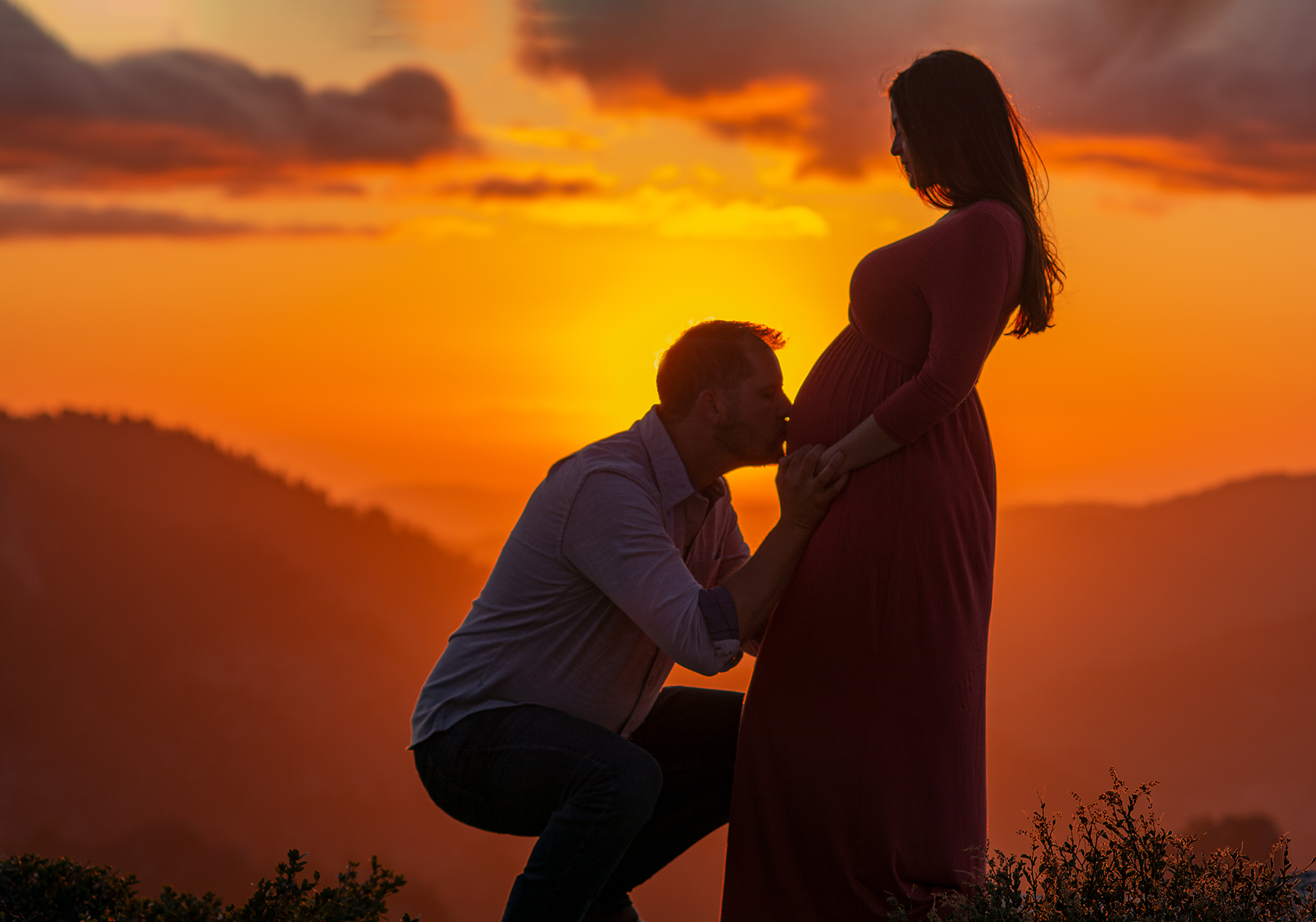 Maternity-portrait---Dady-kissing-Mom's-belly-during-a-beautiful-sunset