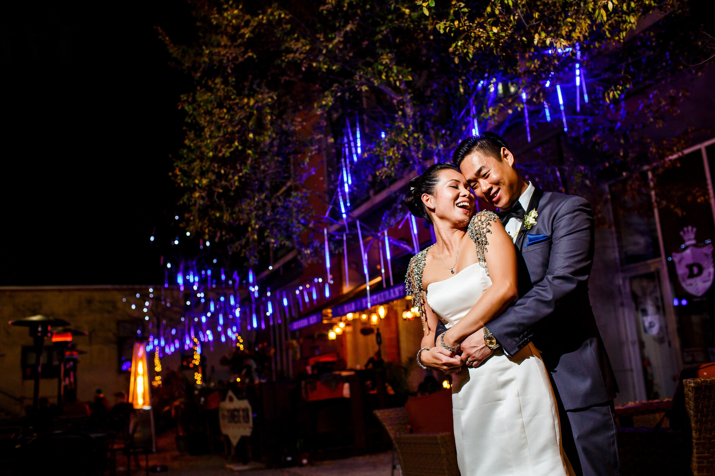 Asian couple in wedding attire candidly lighting at nighttime near Tendenza