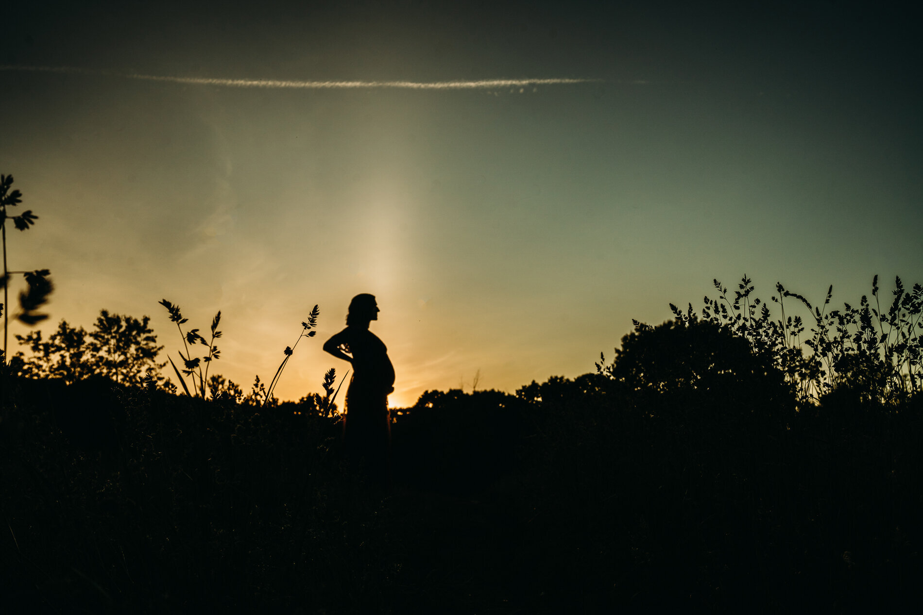 silhouette of a pregnant woman at sunset