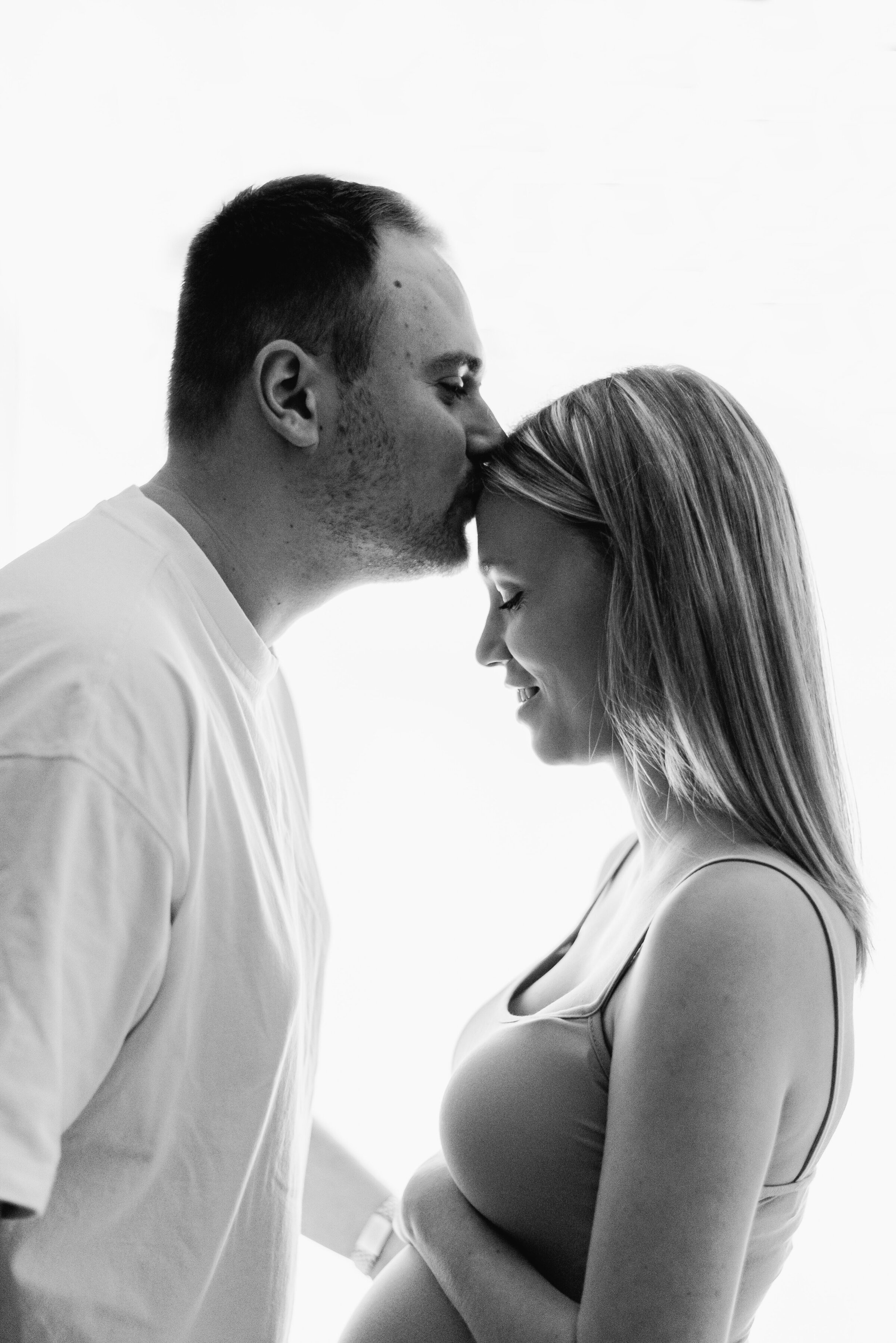 Man kissing womens head in Maternity billingshurst photoshoot