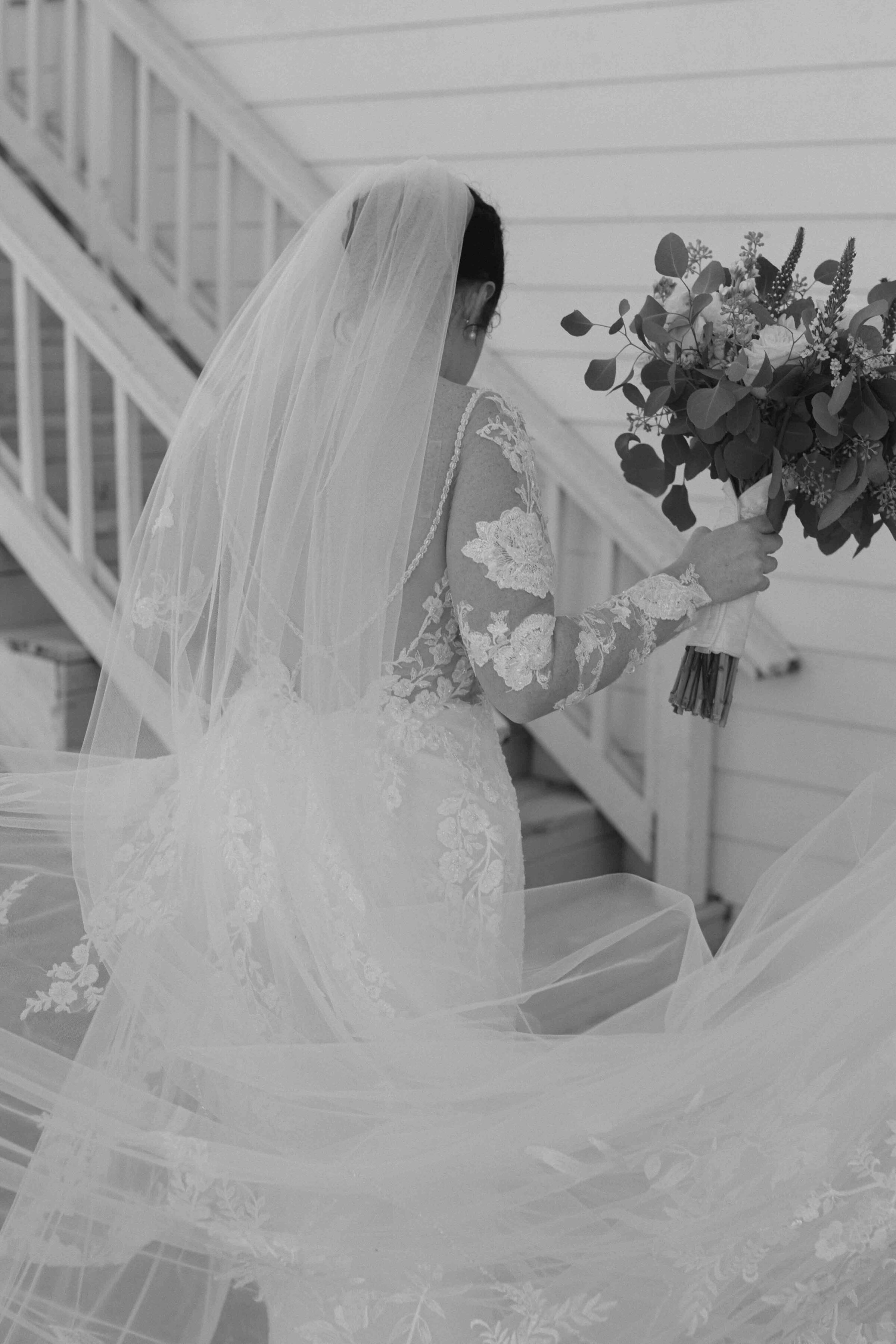 Bride wearing white lace wedding dress holding flower bouquet