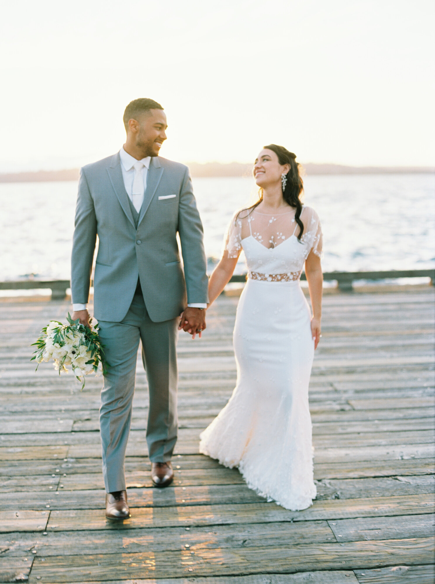 bride and groom on lake dock at golden hour