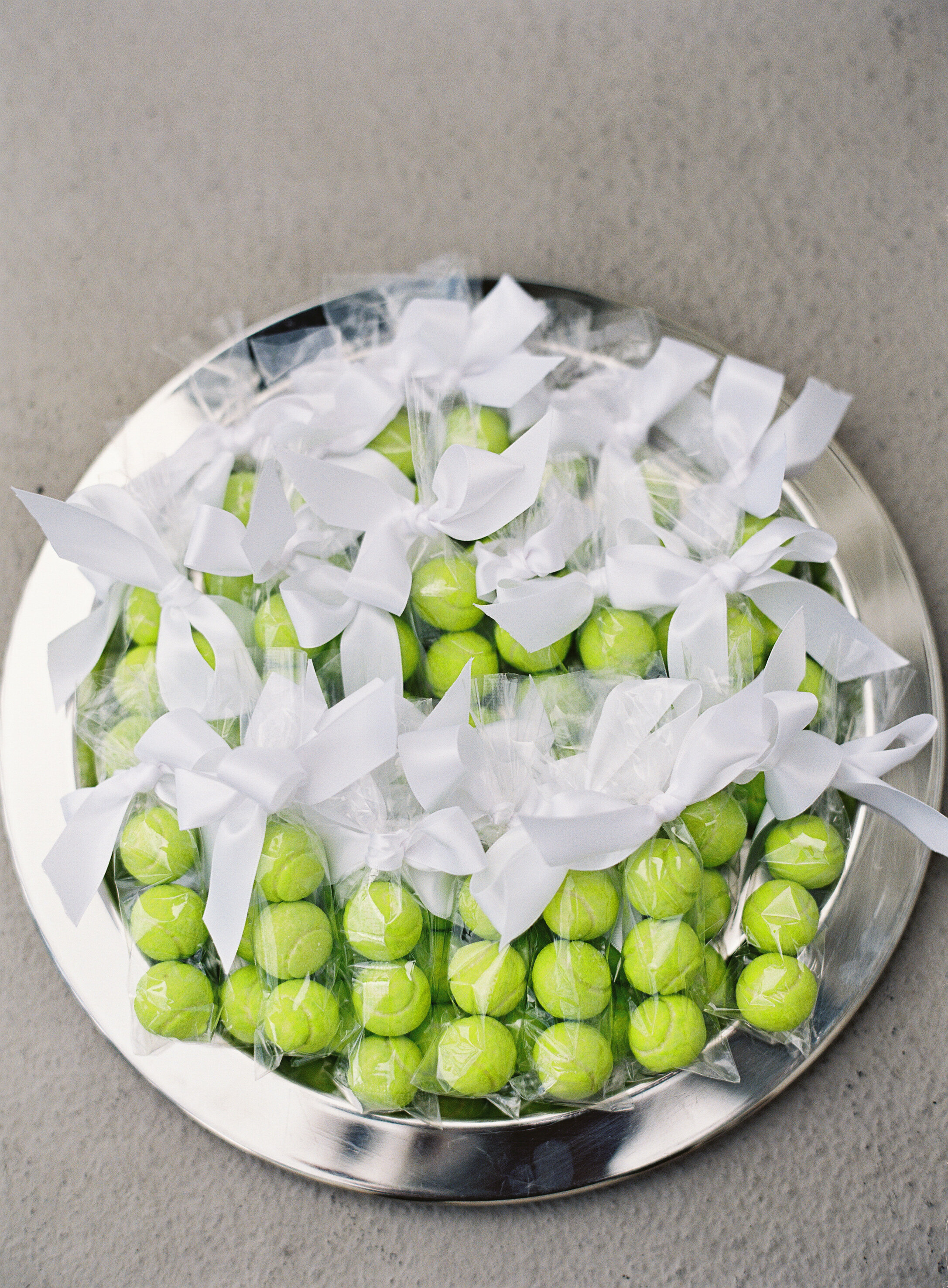 green tennis ball wedding favors on a platter