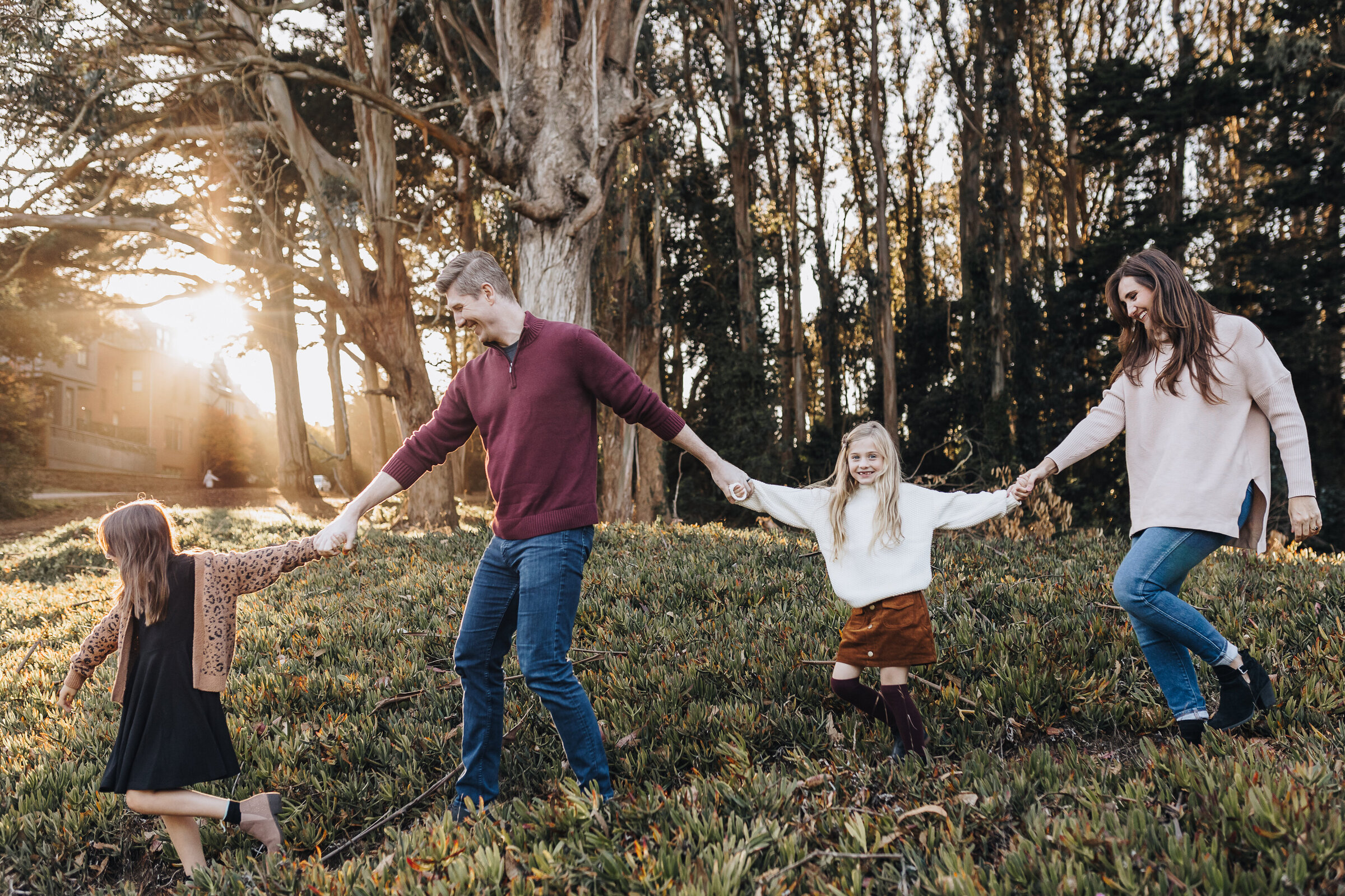 Family walks holding hands through the Presidio in San Francisco