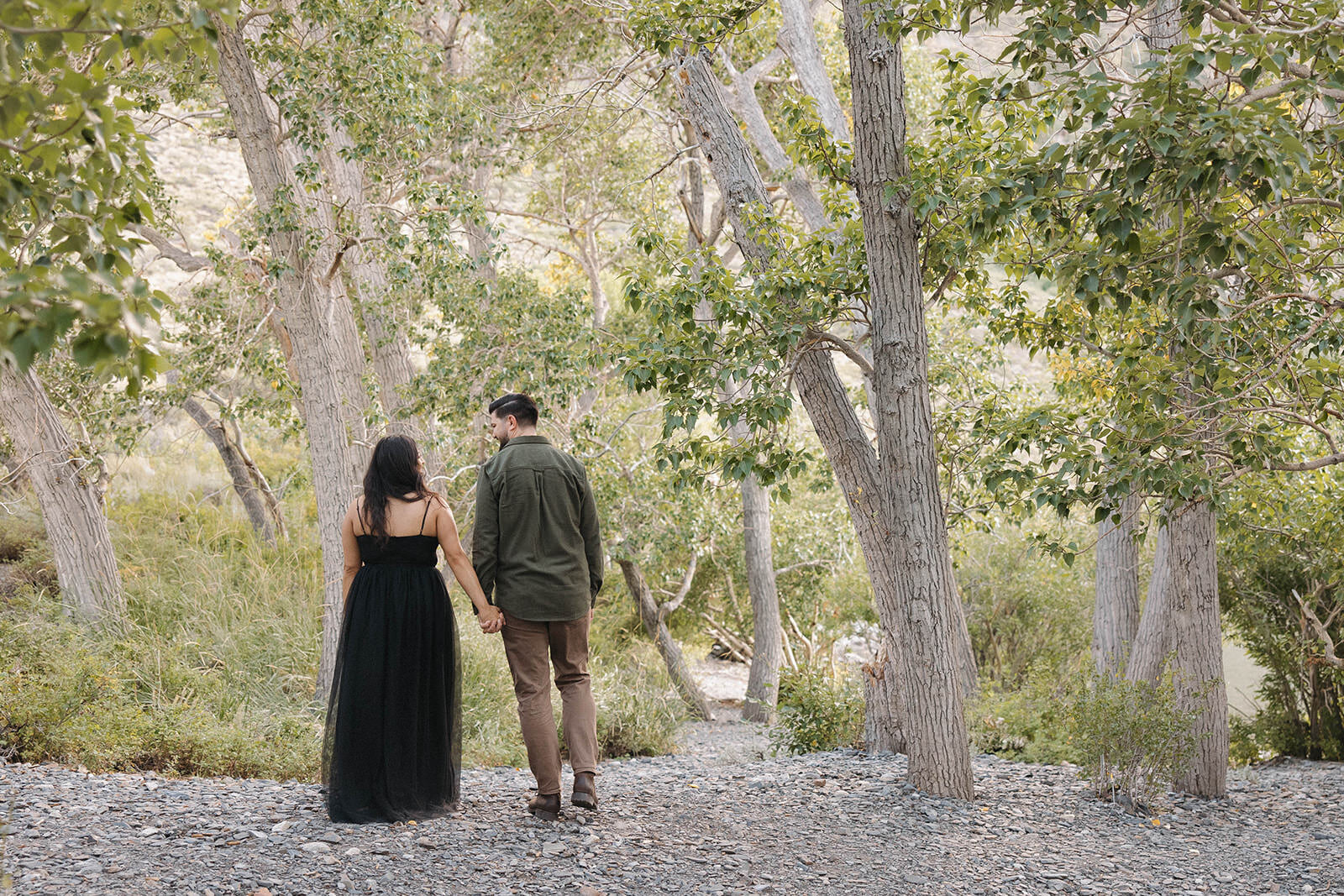 Couple walking through a grove of trees