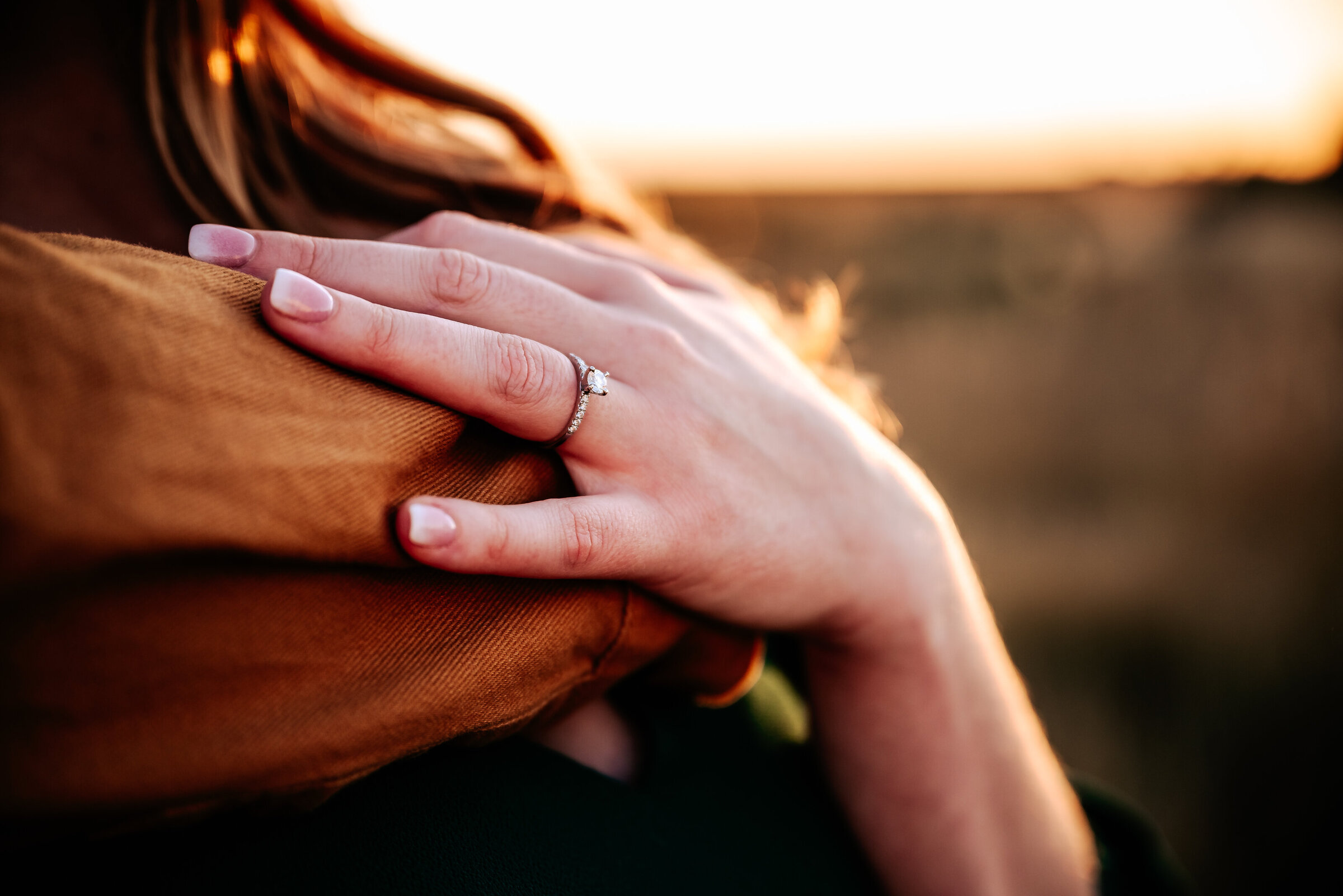 Close up photo of oval engagement ring on woman's hand