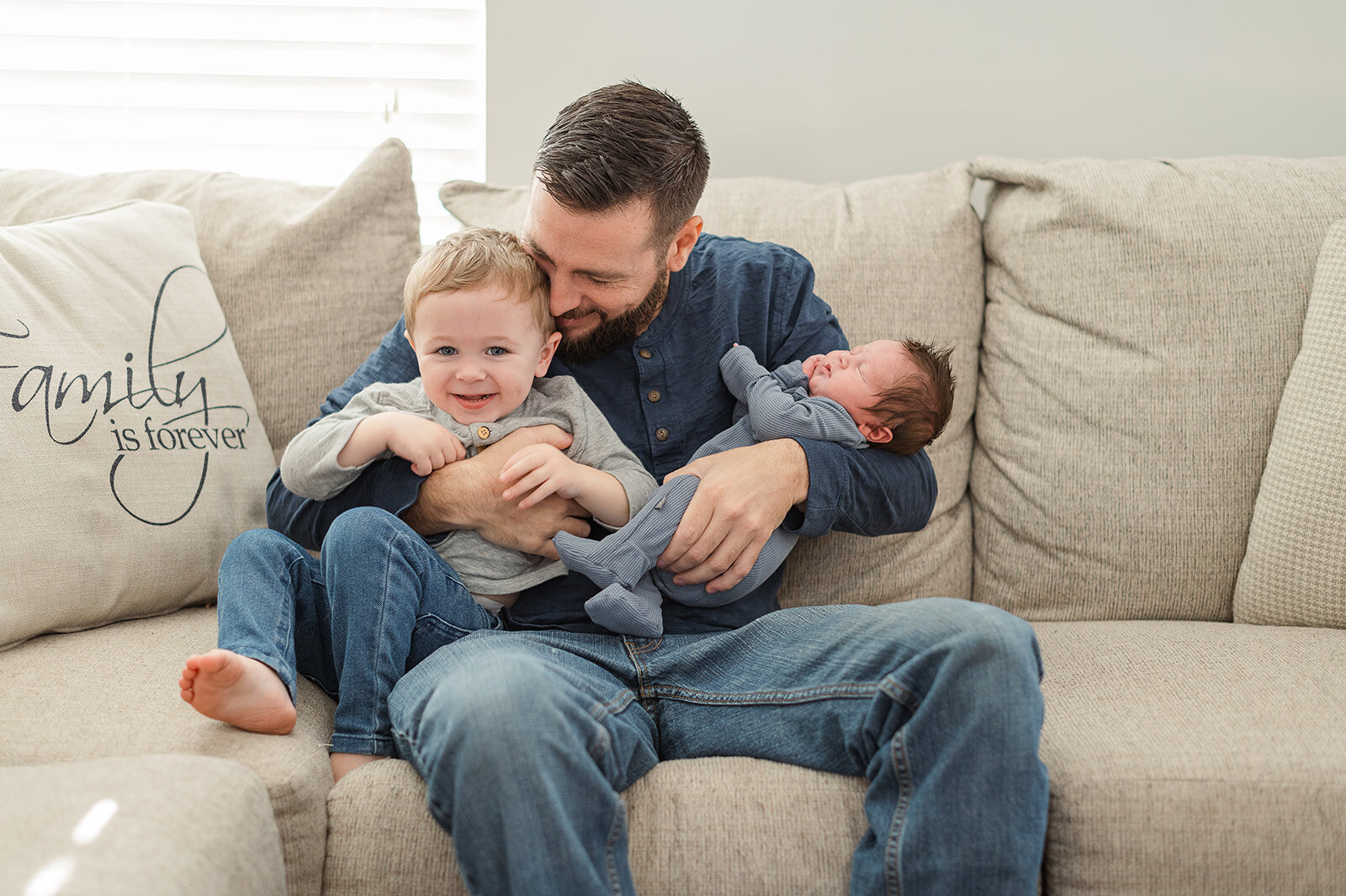 dad snuggling their two children on the couch during a lifestyle family photo session in Harrisburg, PA.