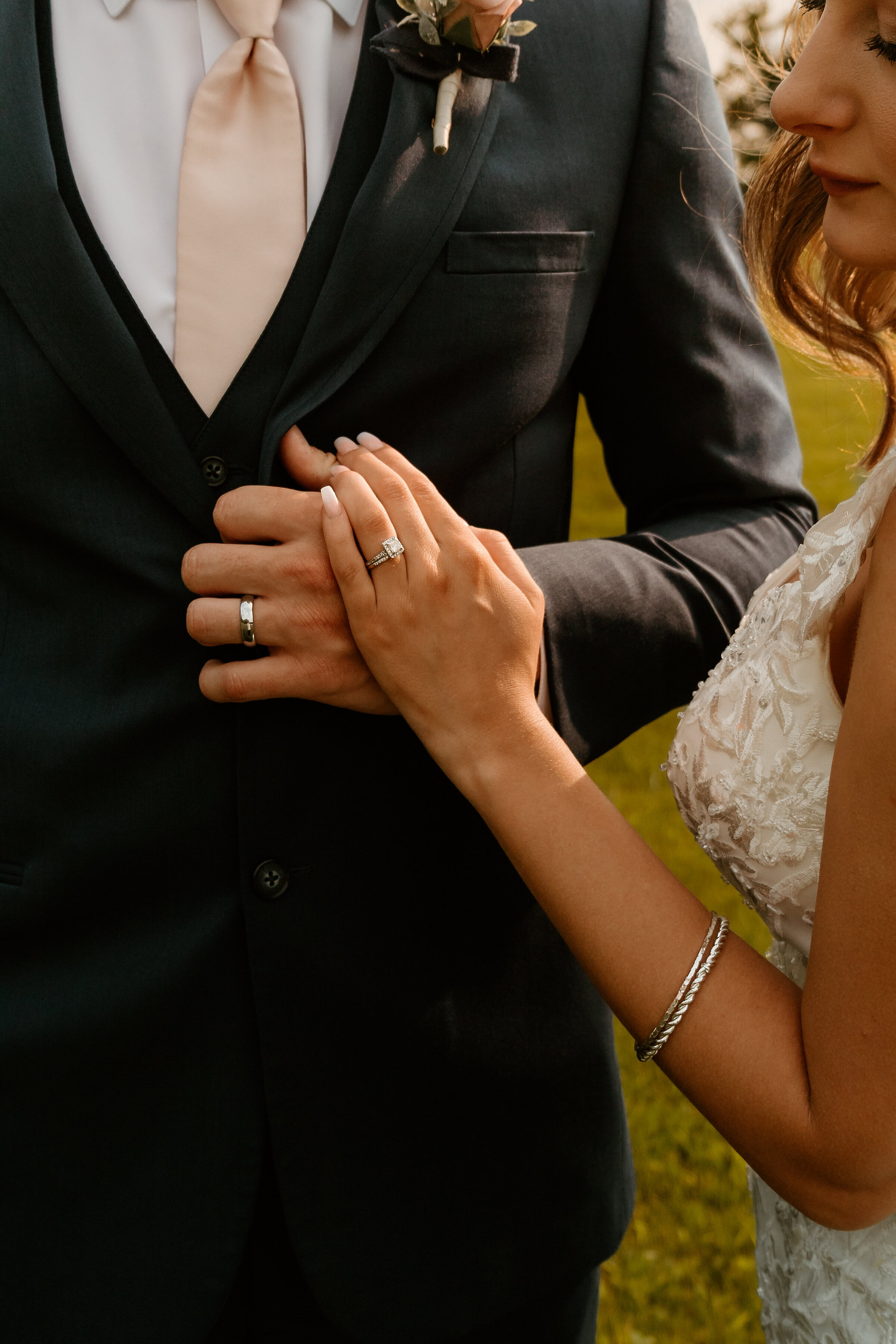 Closeup of the hands of a new couple showcasing their wedding bands