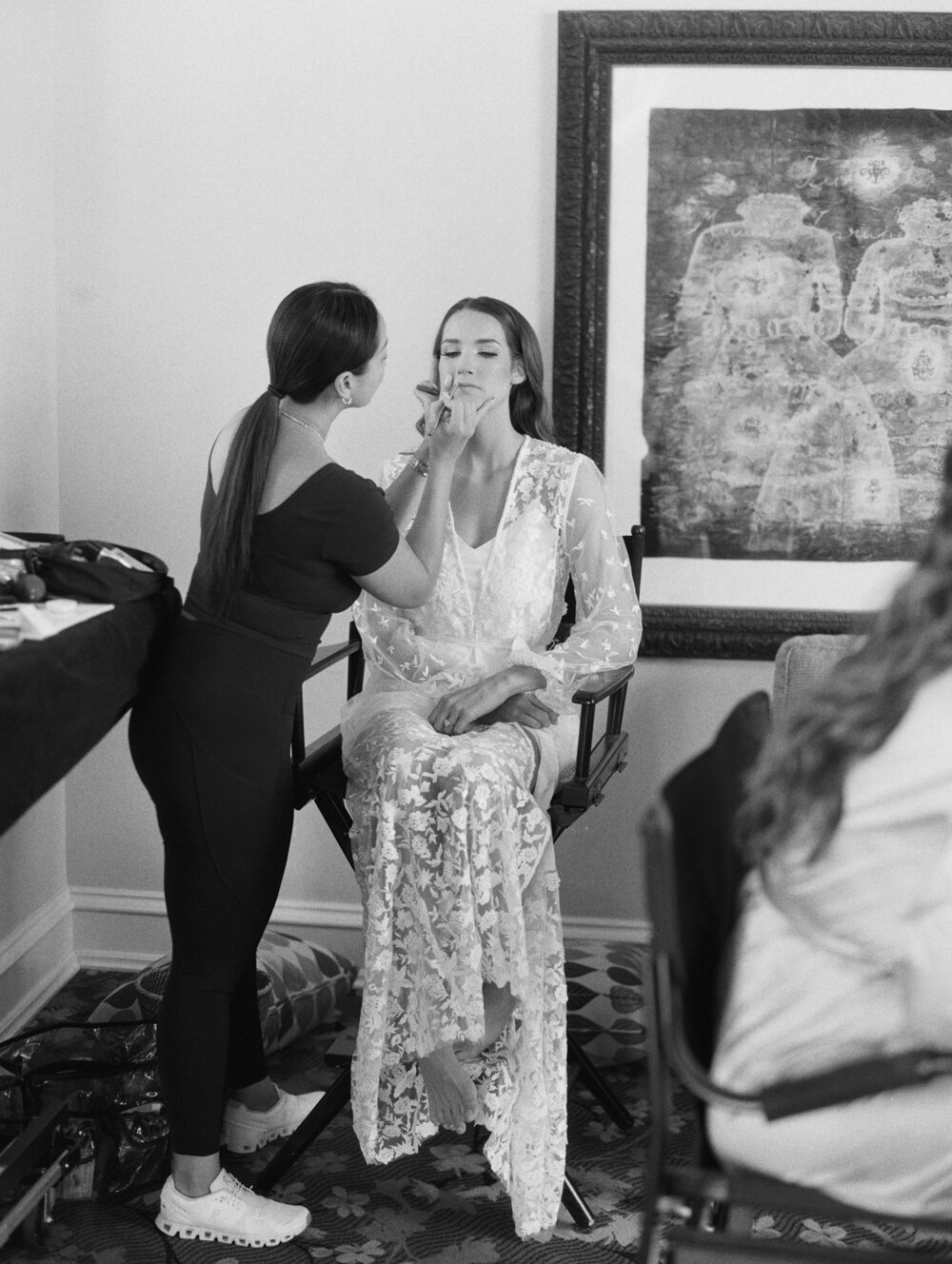 bw film photo of bride getting her makeup done