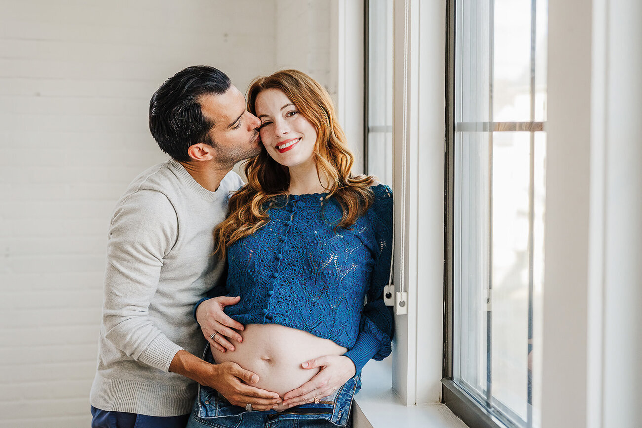 pregnant couple poses for maternity pictures in a boston studio