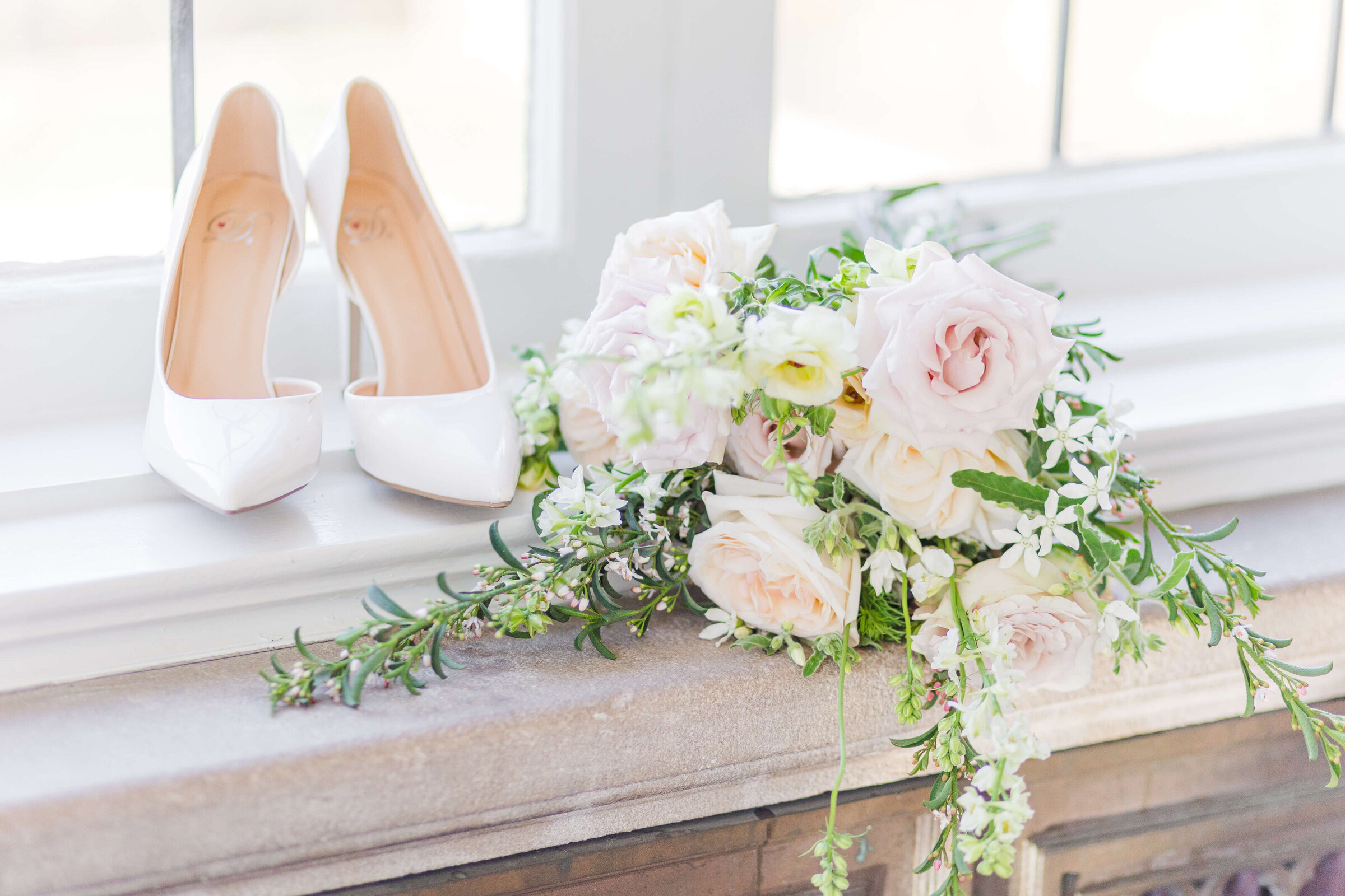 A photograph of white wedding heals and a wedding bouquet with white flowers and greenery.