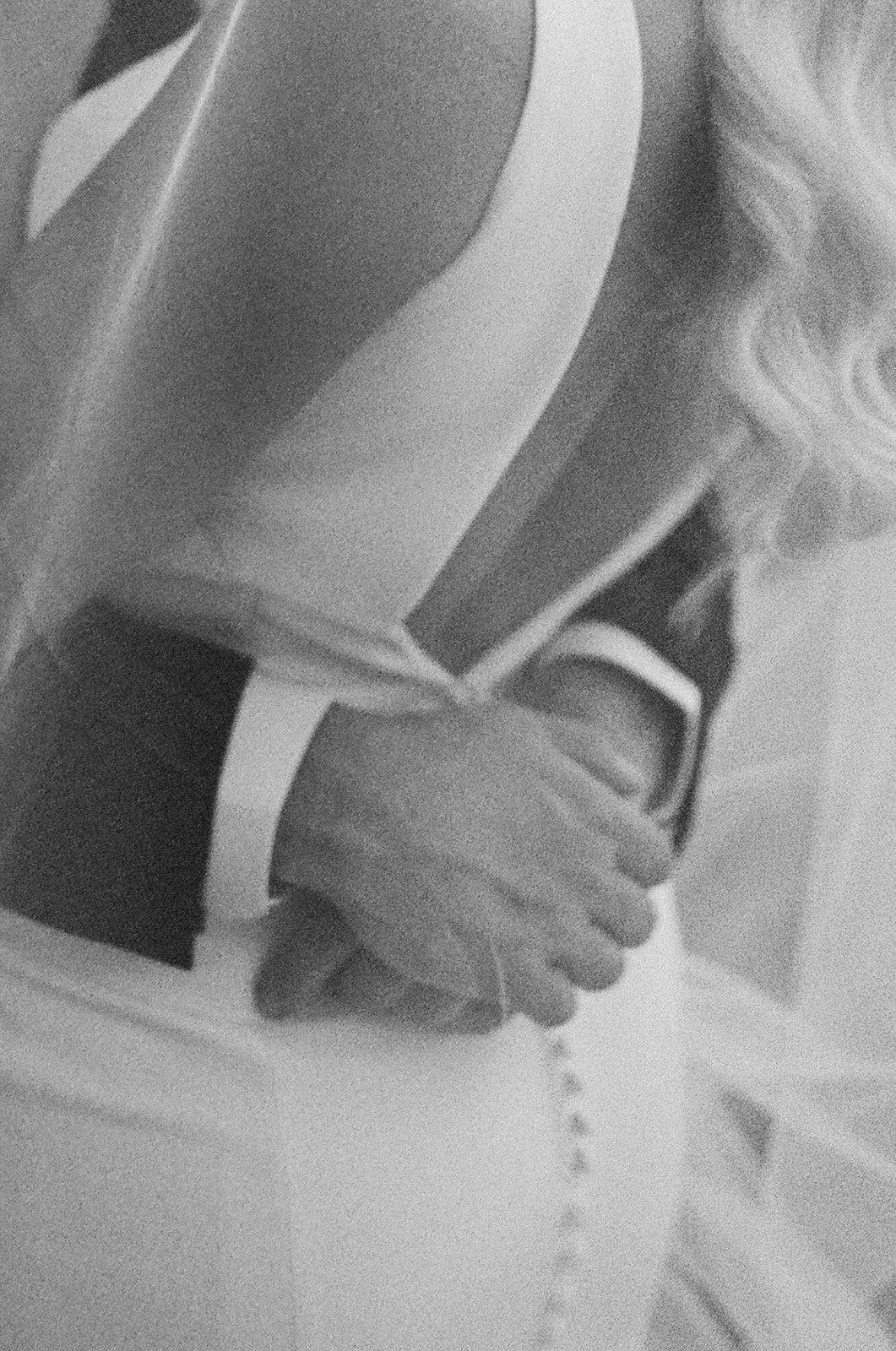 Black and white tightly cropped image of a bride and a groom embracing eachother