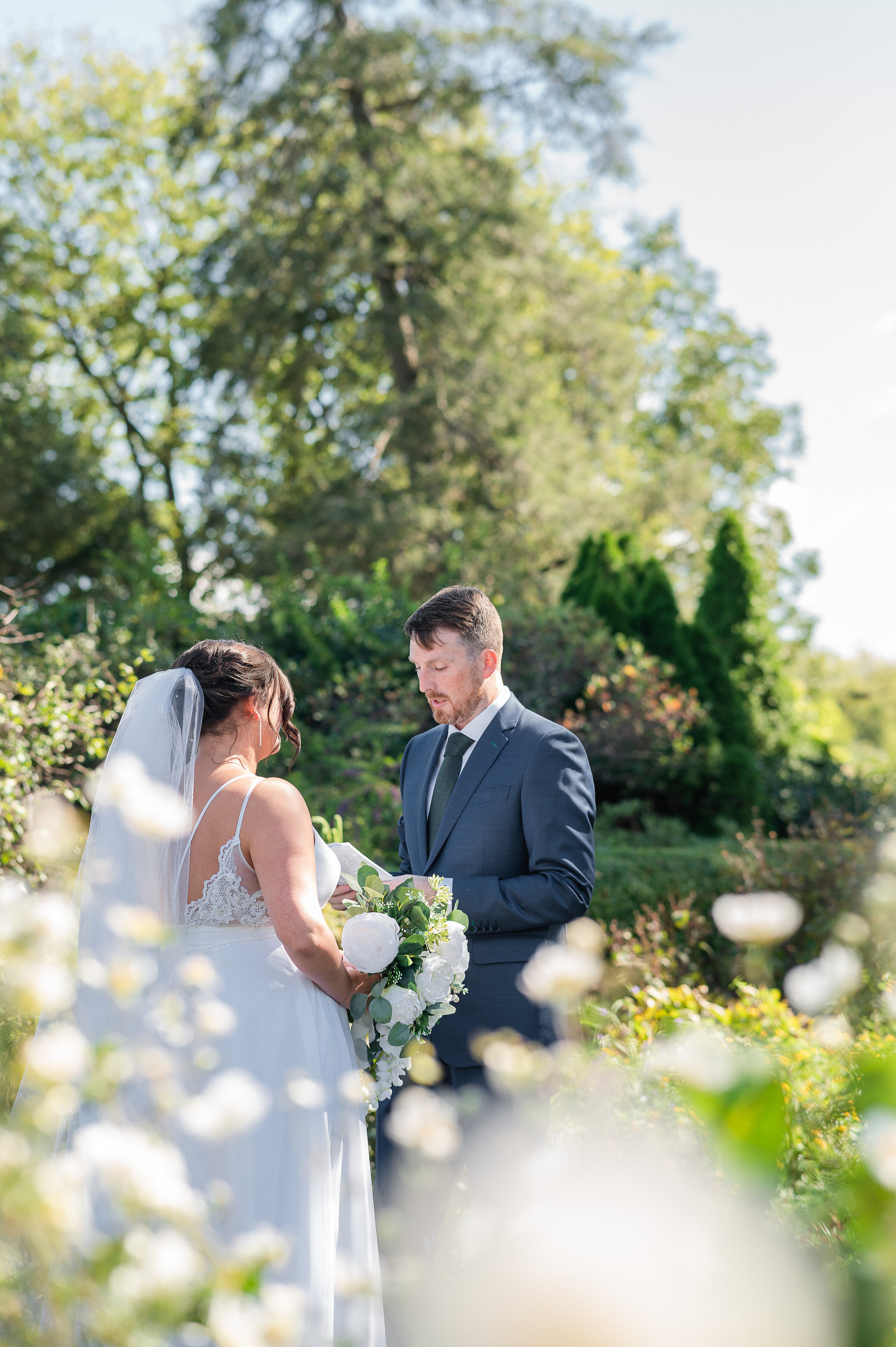 A bride and groom share a first look in a lush garden