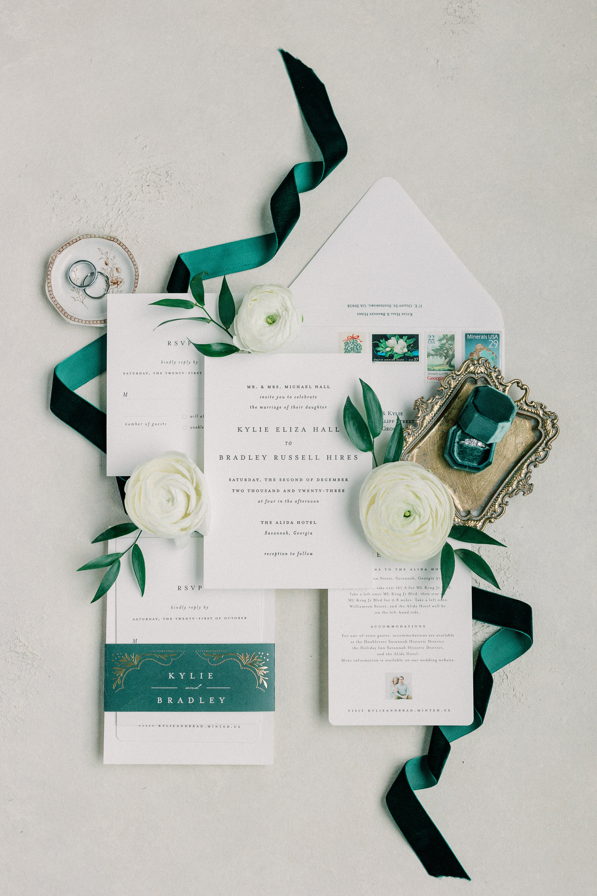 Invitation Suit with wedding rings, green trem, and white flowers