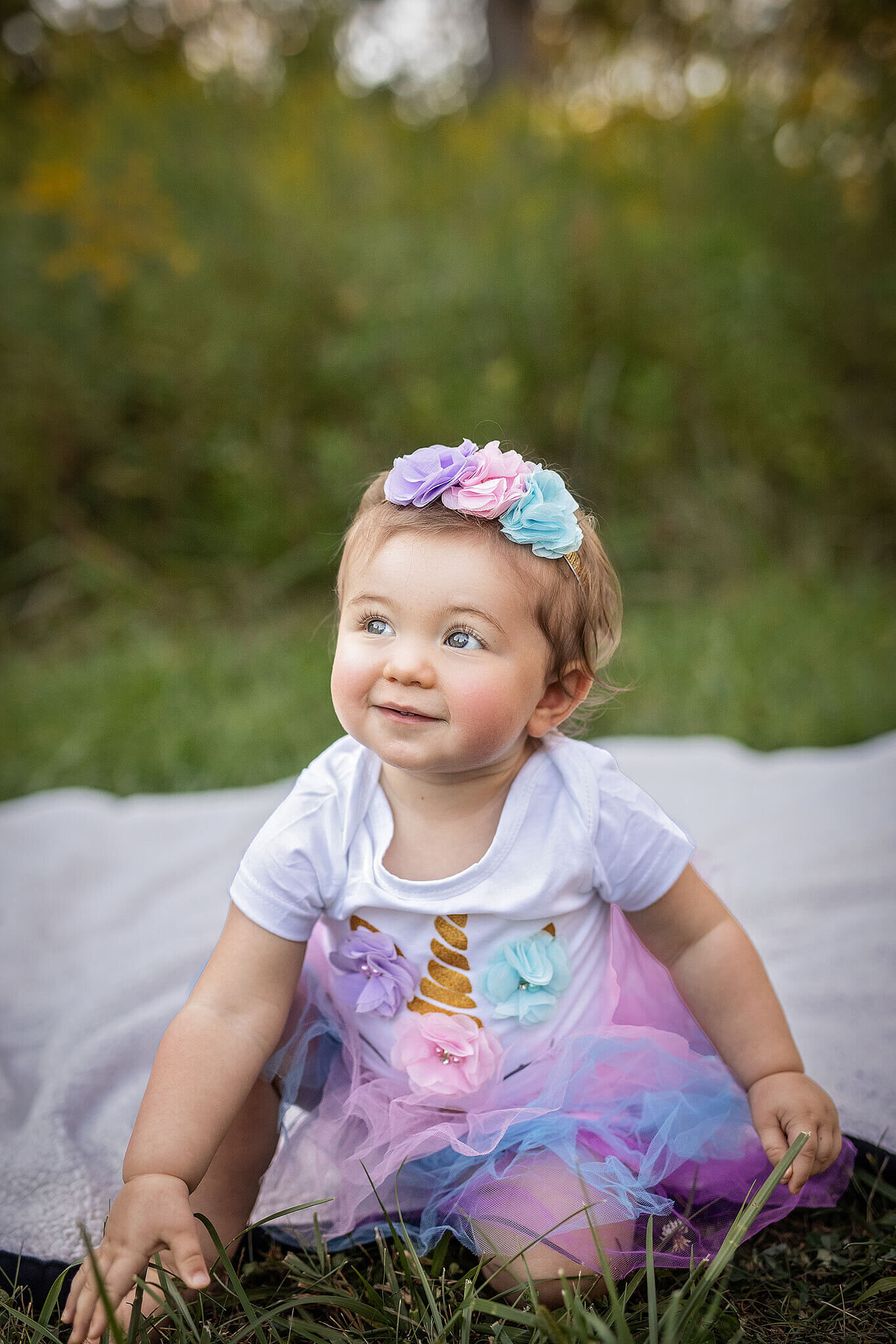 1 year old girl sitting outside at a lowe volk park