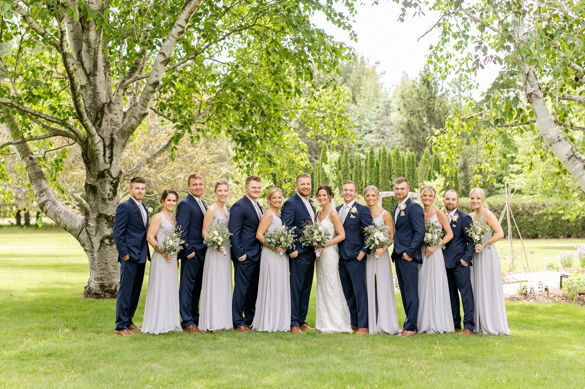 Bridal party standing and holding bouquets, by minneapolis wedding photographers by Kacey Wyrick Photography